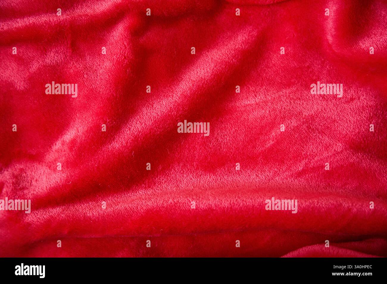 Tissu peluche rouge chatoyant, texture gros plan. Banque D'Images