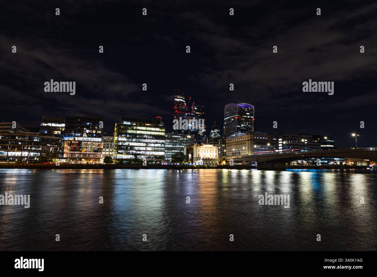 Vue imprenable sur Londres la nuit avec gratte-ciel illuminés et reflets sur la Tamise Banque D'Images