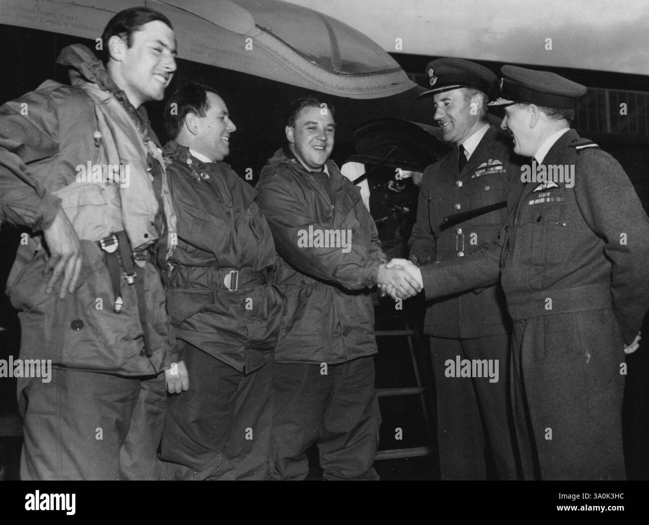 L'équipage de Canberra félicité après le record de la traversée de l'Atlantique dans les deux sens -- juste après un prêt à la base de la Royal Air Force à Aldergrove, comté d'Antrim, Irlande du Nord, après un vol record Ouest-est à travers l'Atlantique de trois heures et 29 minutes (vitesse moyenne de 600 miles à l'heure) dans un bombardier Canberra bi-jet de la Compagnie English-Electric, le commandant Roland Beamont, pilote d'essai en chef de 32 ans de la Compagnie English-Electric Company (à gauche), le Flight-Lieutenant Peter Hillwood, deuxième pilote, de Londres, et l'escadron-Denis Watson, âgé de 37 ans, le chef de l'escadron-navigant (C sont félicités Banque D'Images