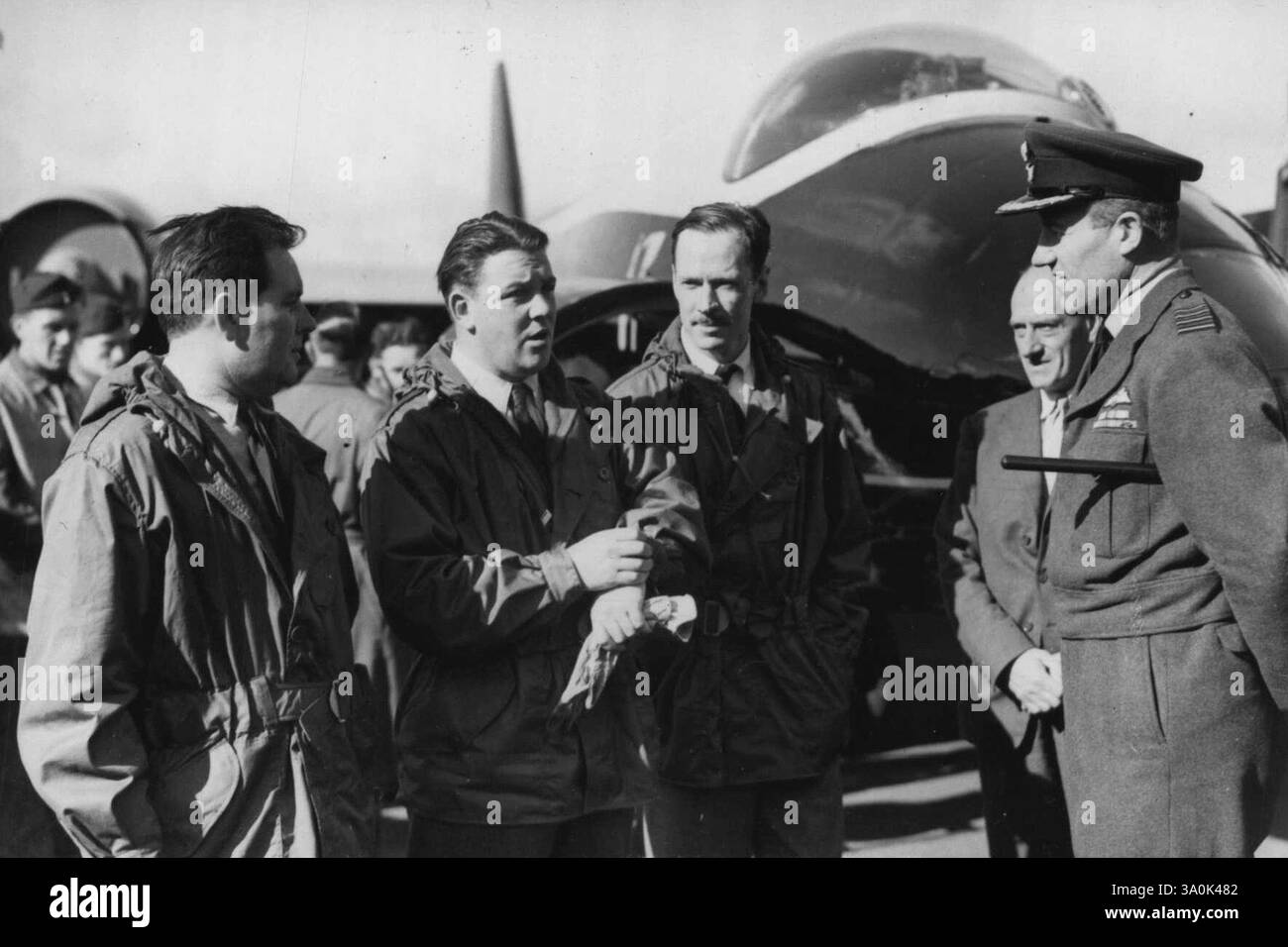 British Jet bat Atlantic Record -- l'équipage de l'enregistrement bat 'Canberra' avant leur départ. De gauche à droite : M. D. A. Watson (navigateur) ; le commandant d'escadre Roland Beaumont, pilote d'essai en chef de l'English Electric Company ; et M. R.H.Y. Rylands (opérateur sans fil) discutant avec le commandant de la station, le capitaine de groupe D.I. Coots, C.B.E. l'un des observateurs officiels. 31 août 1951. (Photo de Sports & General Press Agency Limited). Banque D'Images