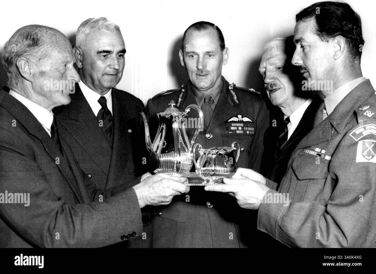 Présentation des officiers de Malaisie. Le Liuet-général Gordon Bennett (à gauche) qui commandait le 2e A.I.F. en Malaisie fait une présentation au nom des officiers du 2e A.I.F. Malaya au lieutenant-colonel J.G. Ochiltree, commandant du 2e bataillon R.A. R., pour la force qui se rendra en Malaisie la semaine prochaine. La présentation consistait en un service de café en trois pièces, dont les pièces ont toutes plus de 100 ans. De l à R. lieutenant-général Gordon Bennett, brigadier F.G. Galleghan, lieutenant-général E.W. Woodward, lieutenant-général Sir Horace Robertson (colonel honoraire Royal Australian Regt., et lieutenant-colonel J.G. Ochilt Banque D'Images