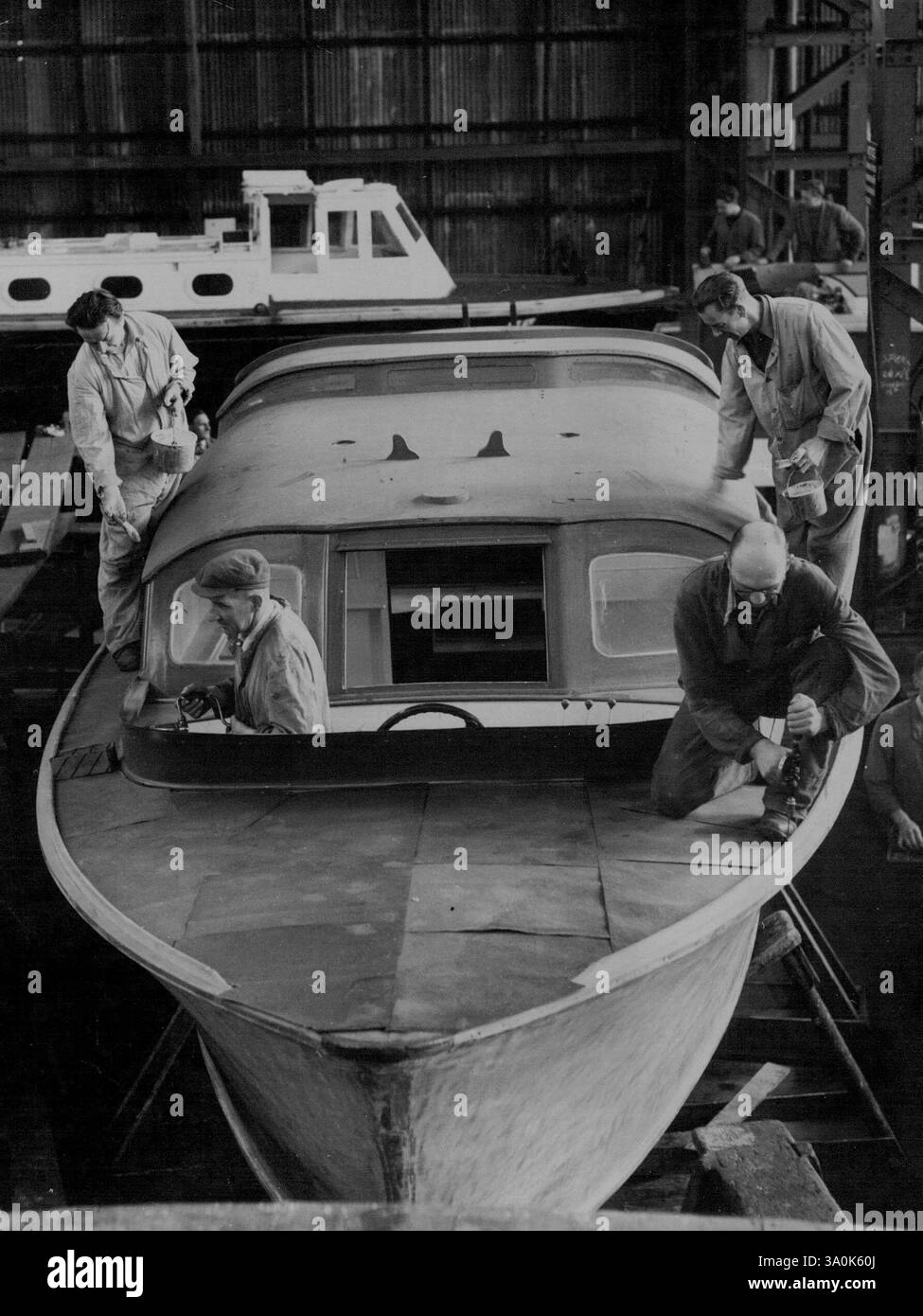 La barge royale de Britannia est prête pour l'examen du couronnement -- ***** Travaillant sur la barge royale à ***** . La barge royale pour le nouveau yacht royal Britannia (lancé récemment par le Queen on Clydeside) est en cours de préparation à Portsmouth Dockyard. La barge, construite par une firme de Portamouth en 1938, est en cours ***** Re-peint et re-doré par une bande d'artisans qualifiés dans le grand hangar à bateaux Dockyards. Avant que la barge ne «rejoigne» le Britannia, elle sera présente sur H.M.S. surprise (le veseel d'expédition qui sera utilisé par la reine et le duc d'Édimbourg) pendant le ***** Couronnement Naval Revi Banque D'Images