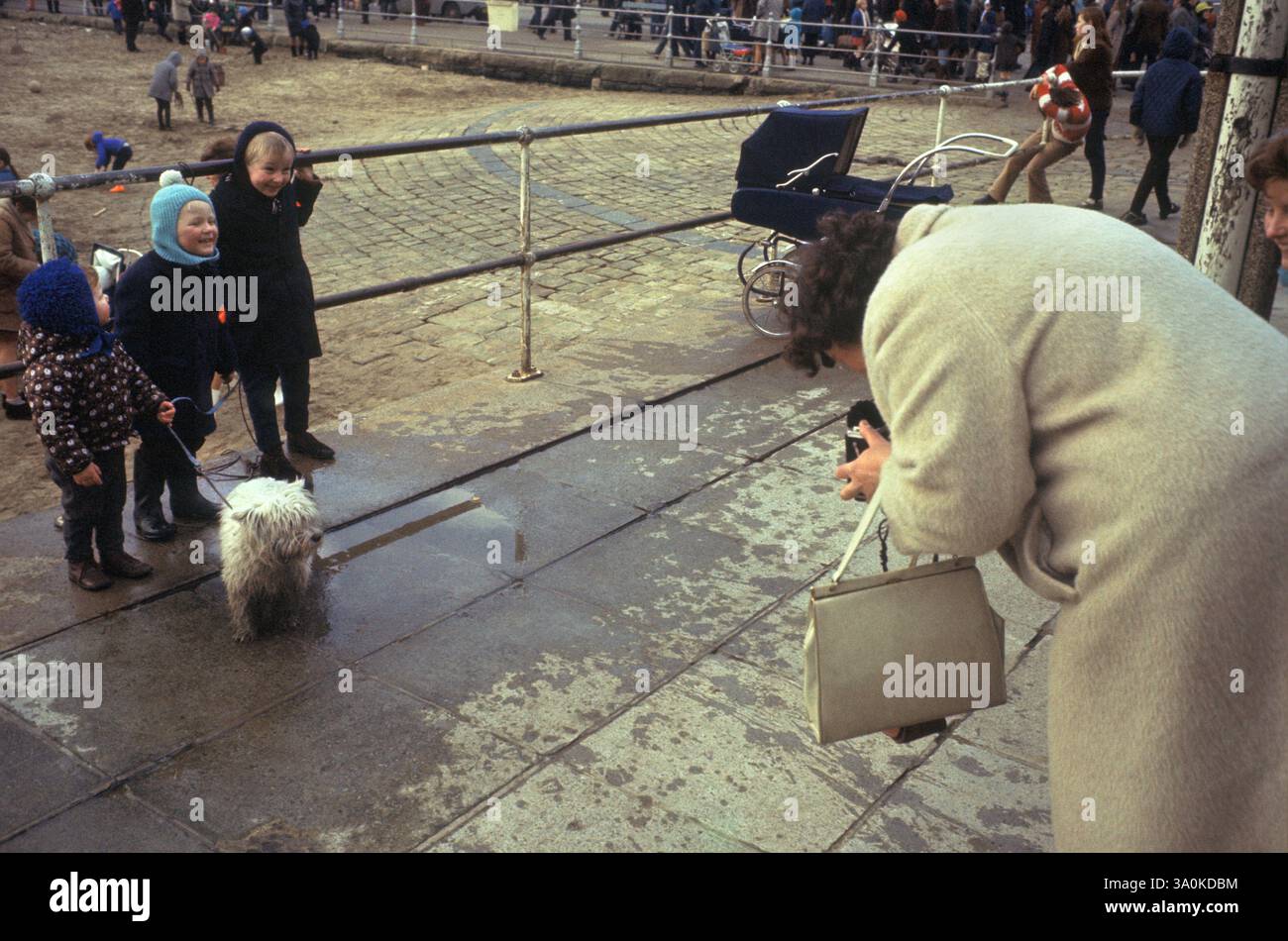 Groupe familial britannique des années 1970 prenant une photo. Mère et ses trois enfants et leur chien de compagnie prennent une photo. Scarborough Yorkshire Angleterre HOMER SYKES Banque D'Images