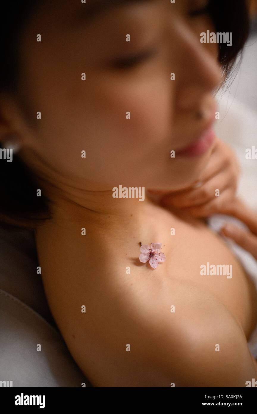 femme portrait gros plan avec des fleurs roses près du visage Banque D'Images