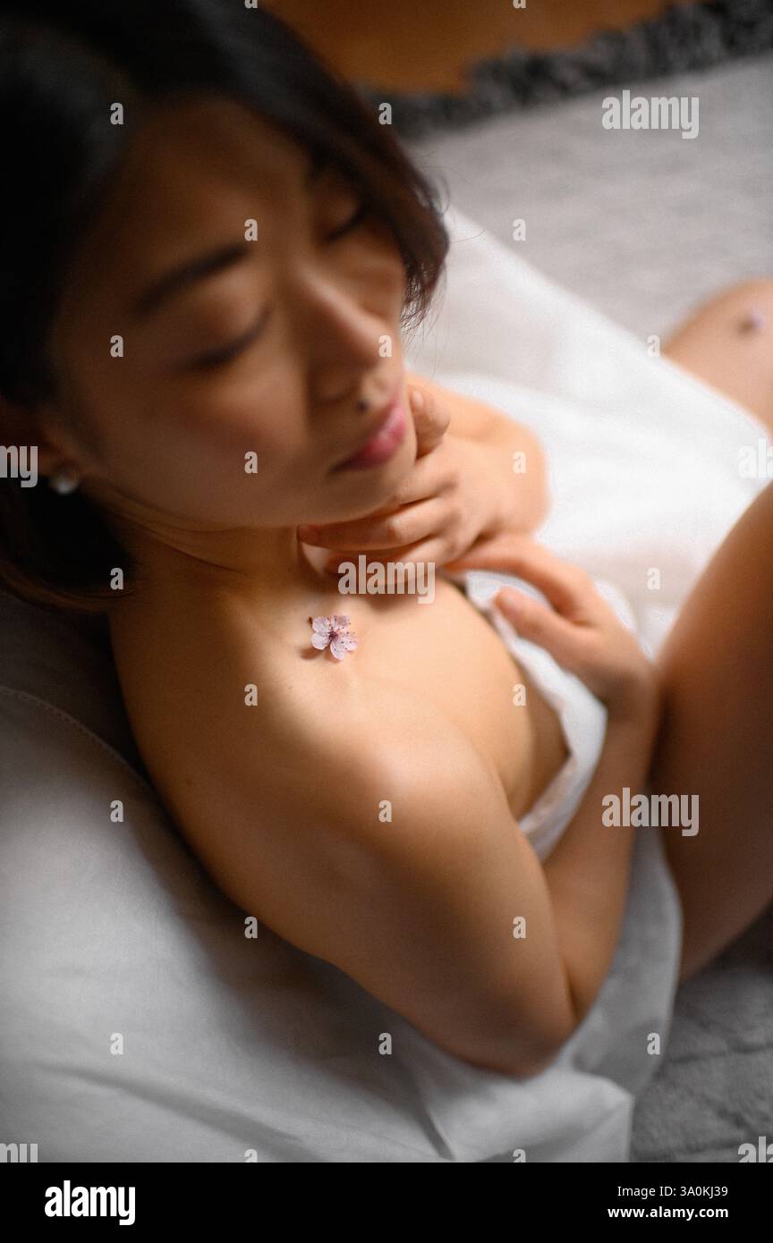 femme portrait gros plan avec des fleurs roses près du visage Banque D'Images