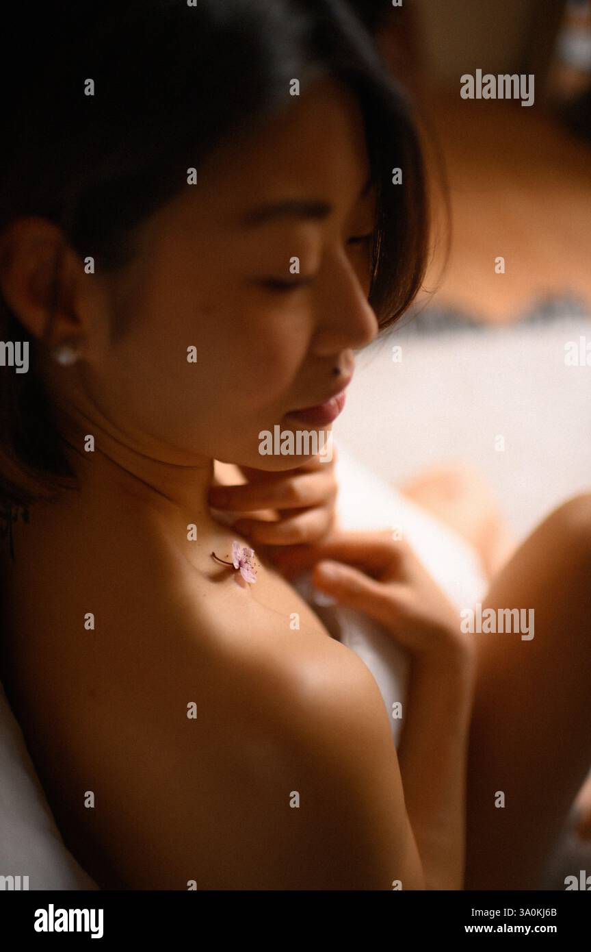 femme portrait gros plan avec des fleurs roses près du visage Banque D'Images