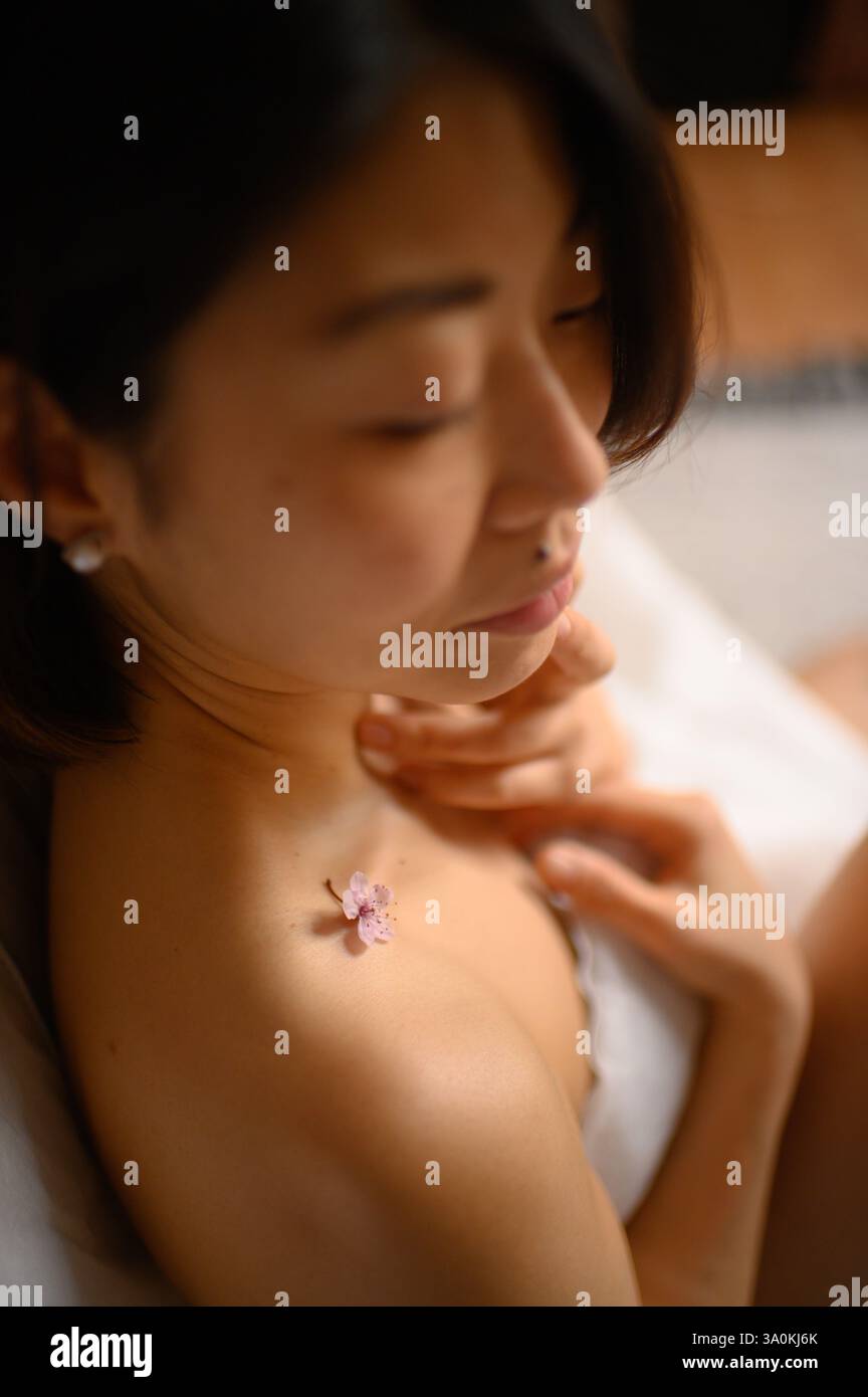 femme portrait gros plan avec des fleurs roses près du visage Banque D'Images