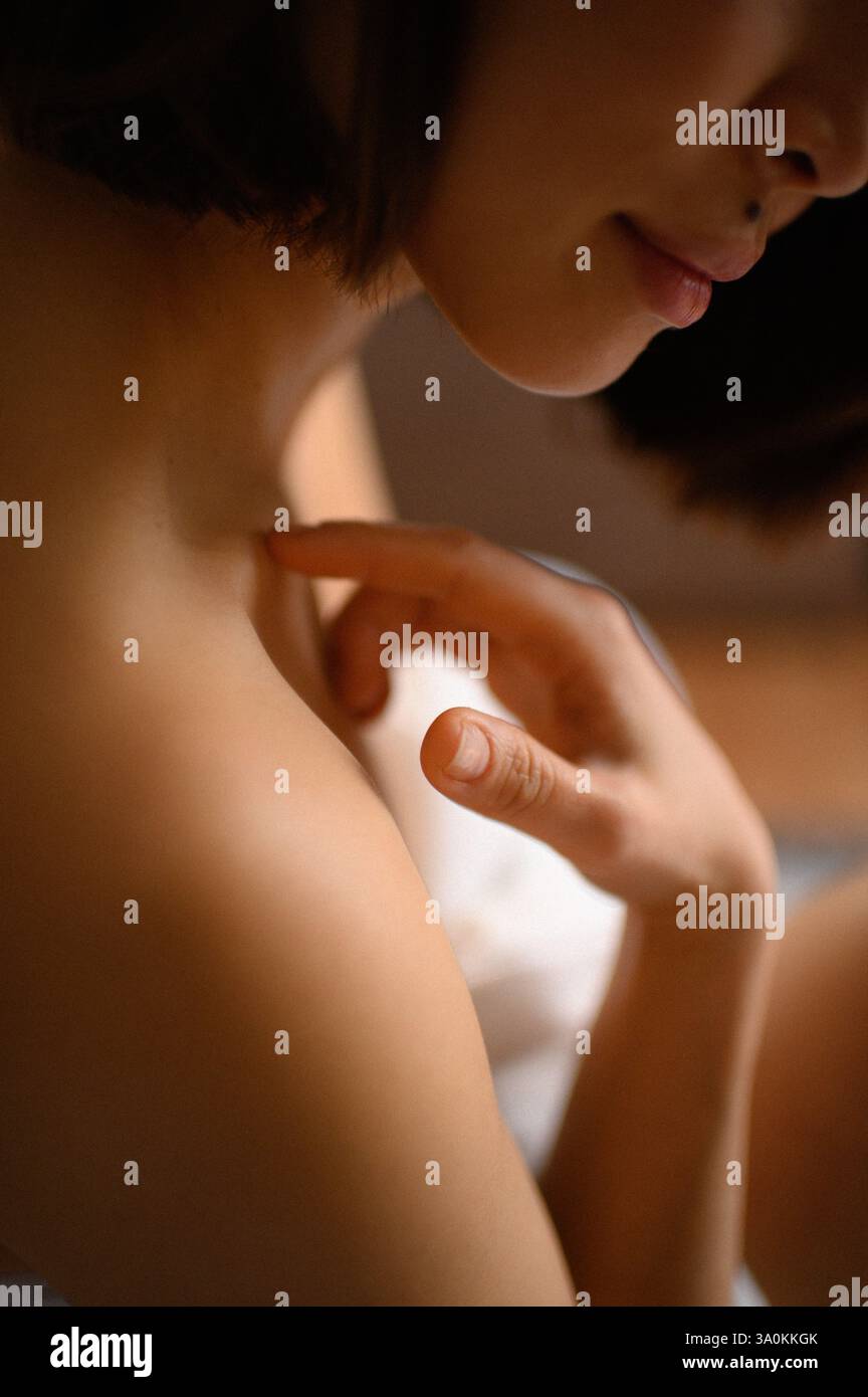 femme portrait gros plan avec des fleurs roses près du visage Banque D'Images