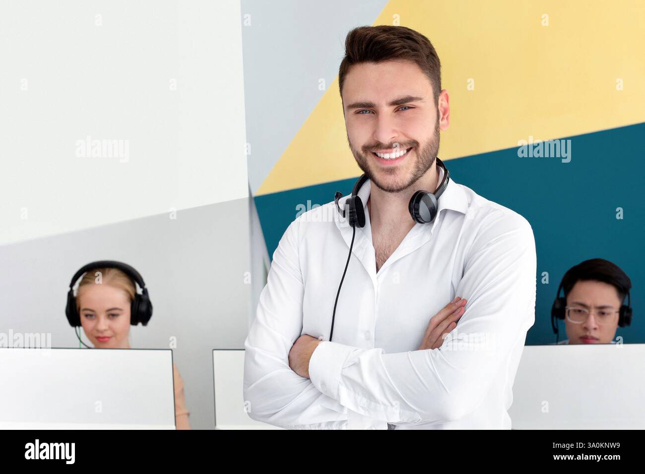 Portrait d'un représentant positif du service clientèle et de ses collègues au centre d'appels contemporain Banque D'Images
