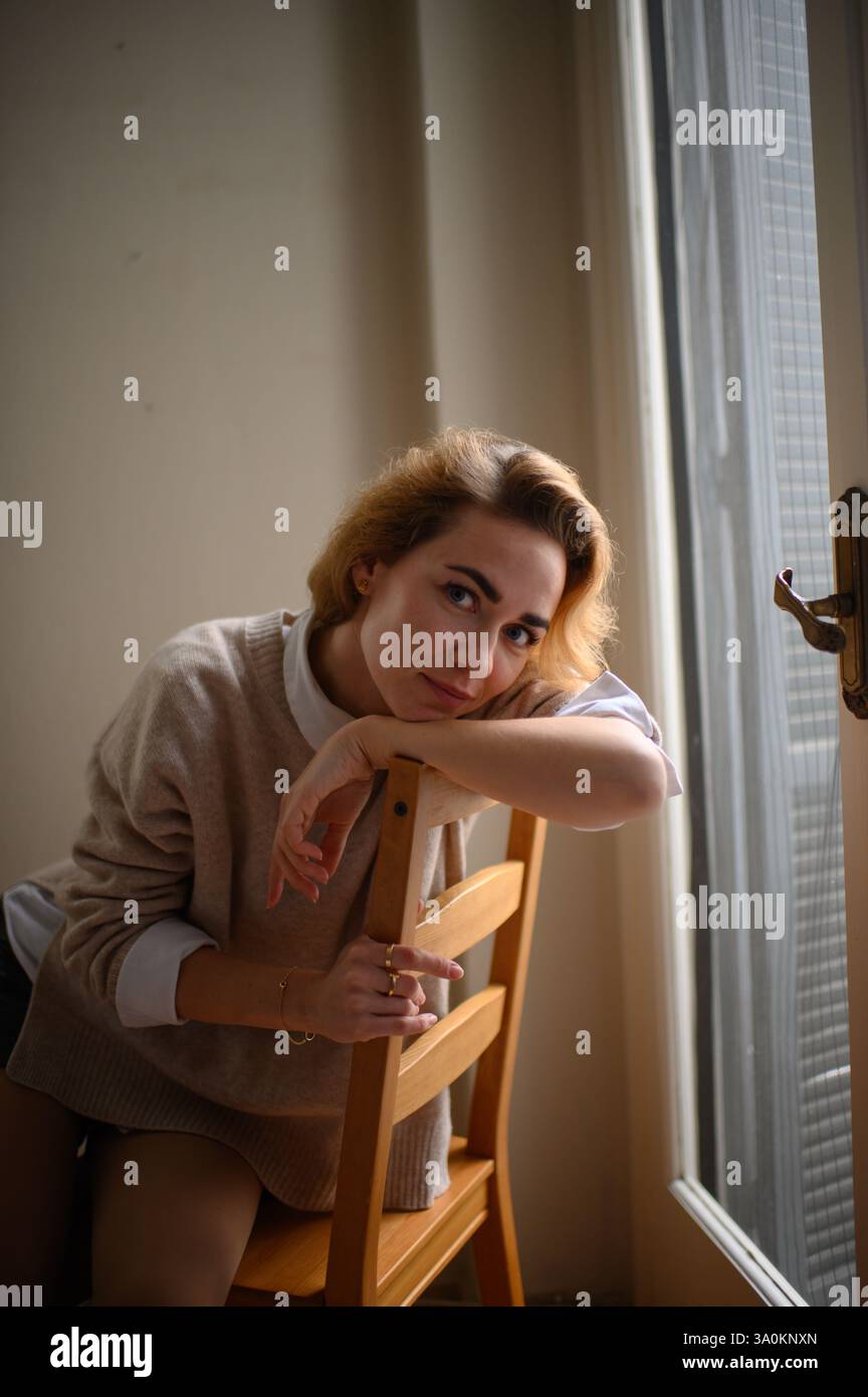 femme sur la chaise près de la fenêtre Banque D'Images