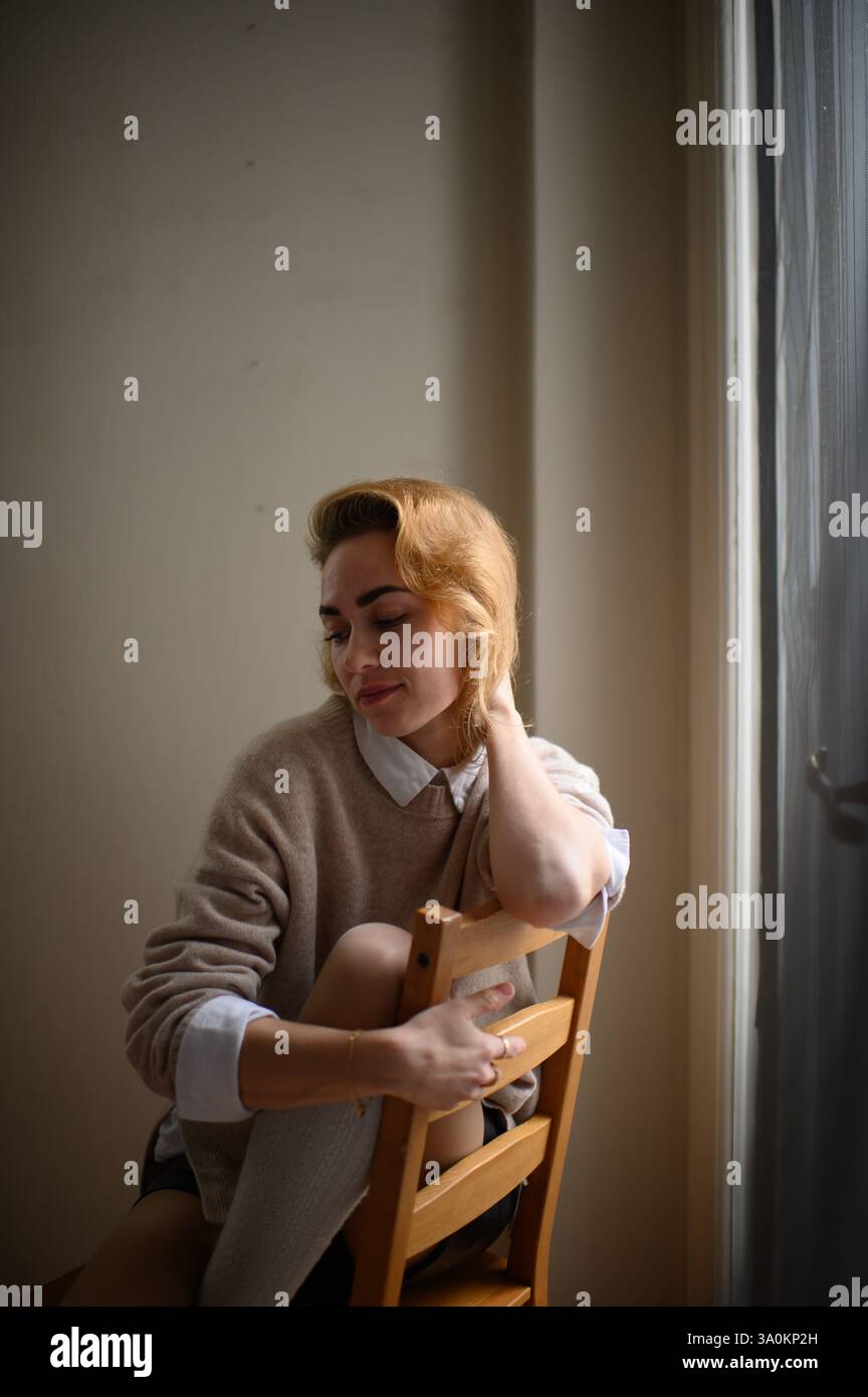 femme sur la chaise près de la fenêtre Banque D'Images
