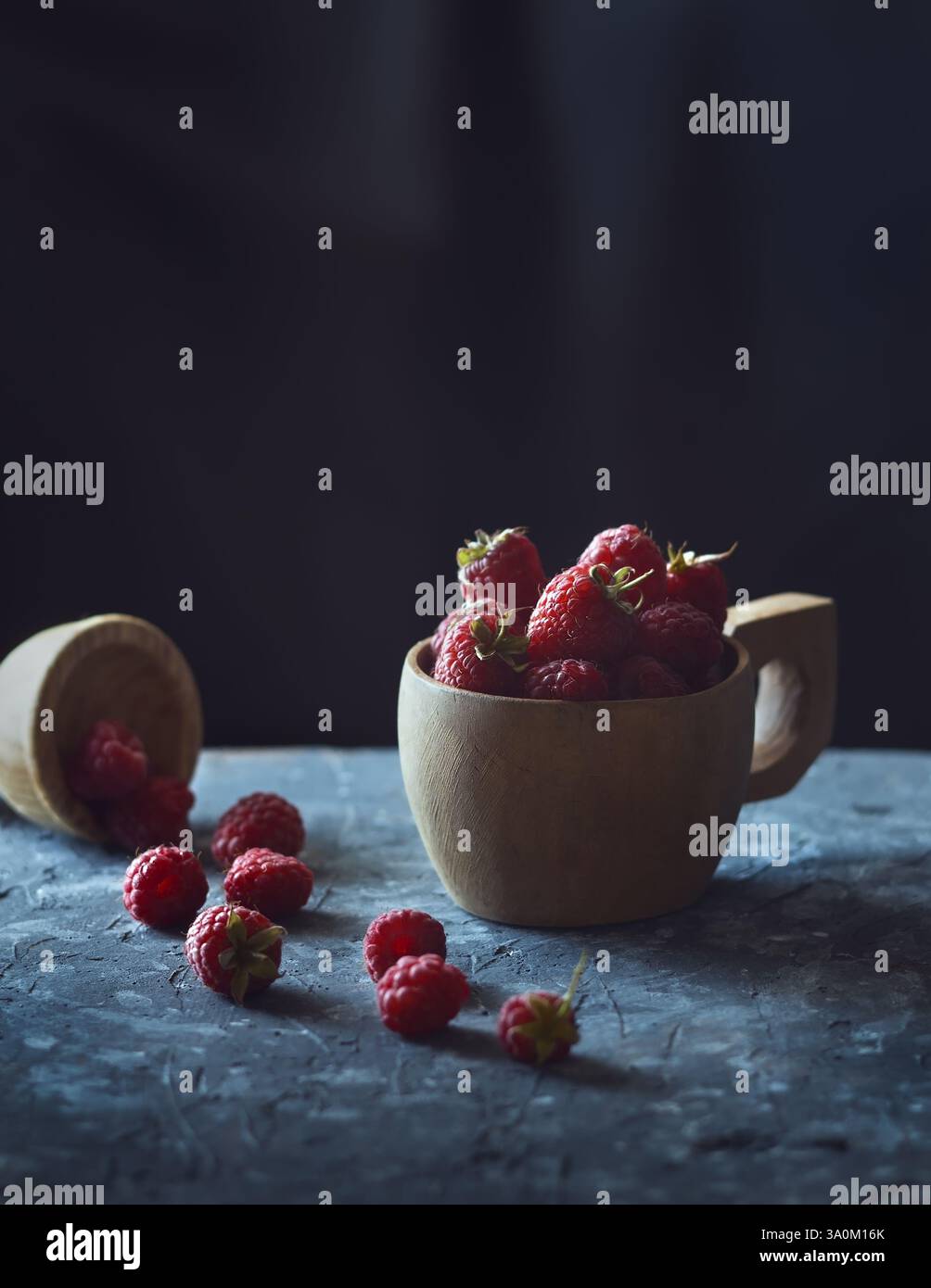 Framboises dans une tasse en bois sur la table gros plan. Art nature morte. Banque D'Images