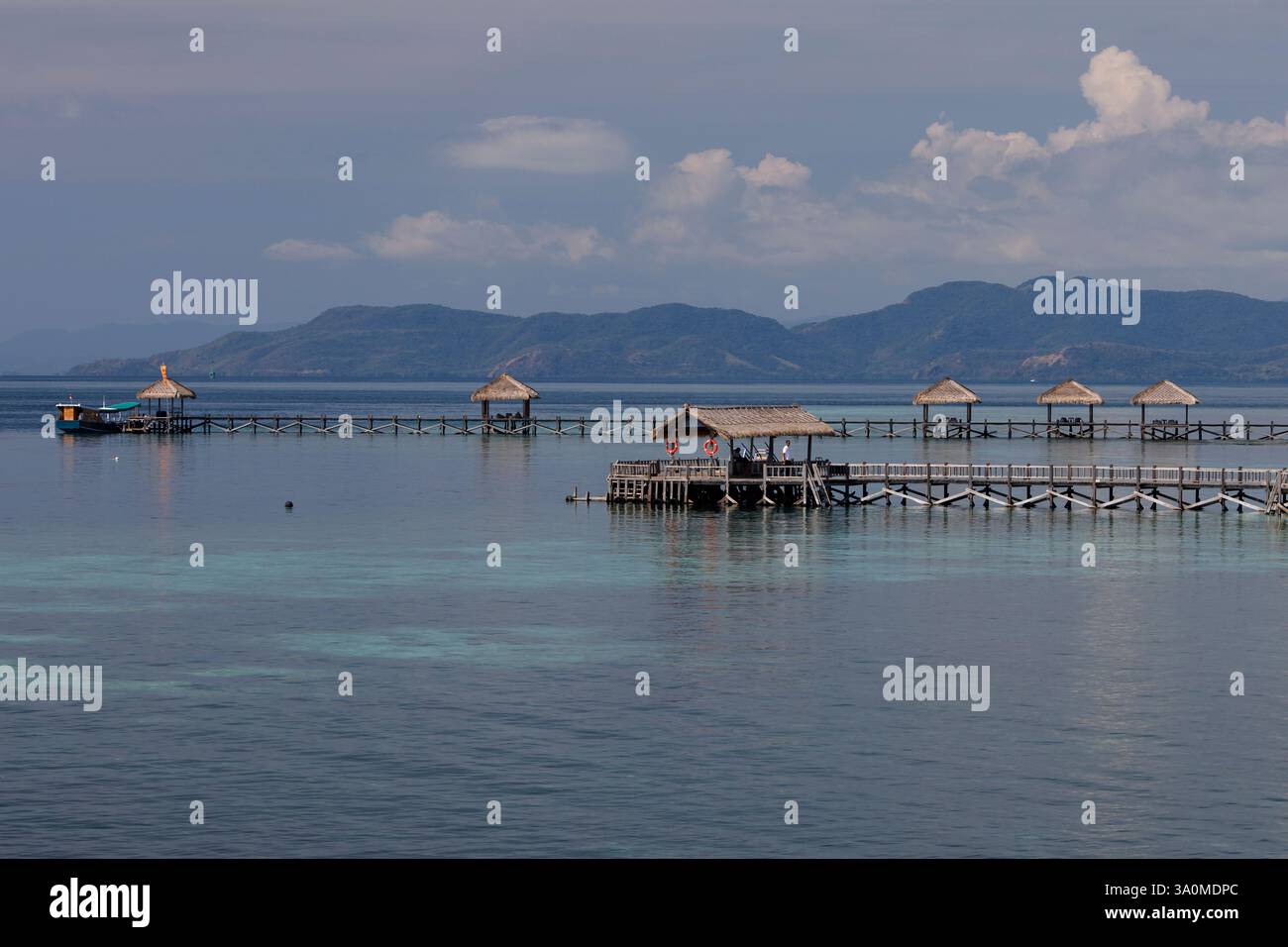 Vue sur les quais et les cabanes tiki sur l'île de Seraja Kecil, également connue sous le nom de Seraya, au large de la côte de Labuan Bajo, Indonésie. L'île abrite th Banque D'Images