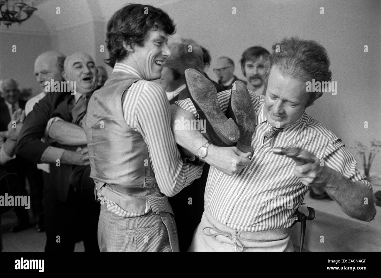 Shoeing the Colt à Hungerford Hocktide, a lieu le deuxième mardi après Pâques. Après le déjeuner, « poulain » est une personne qui n'a jamais assisté au déjeuner avant, est espiègle et un clou de fer à cheval est censé être enfoncé dans le talon de sa chaussure ; jusqu'à ce qu'il appelle un arrêt en criant « punch ». Hungerford, West Berskshire, Angleterre années 1973 1970 Royaume-Uni HOMER SYKES Banque D'Images