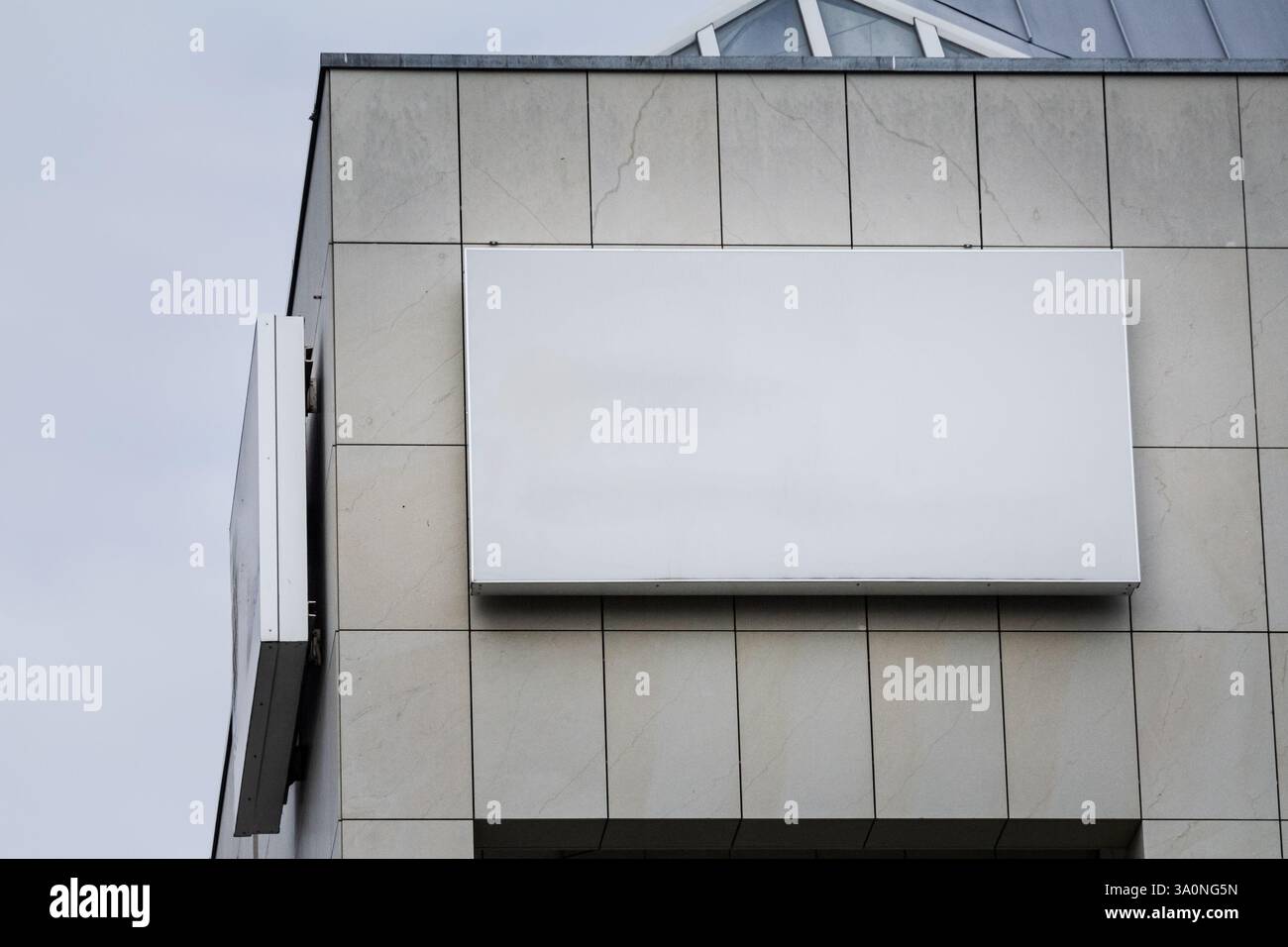 Panneau blanc rectangulaire vide apposé sur la façade d'un immeuble de bureaux en Allemagne. Cet écran vide offre suffisamment d'espace pour une image de marque potentielle Banque D'Images