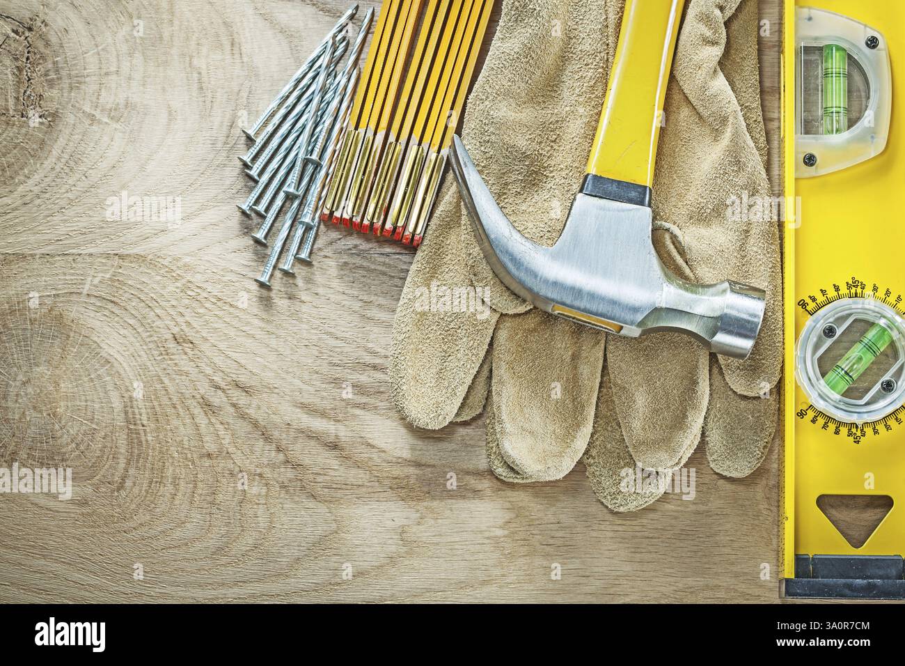 Gants de sécurité en cuir de niveau de construction clous de marteau de mètre en bois sur le concept de construction de panneaux de bois Banque D'Images