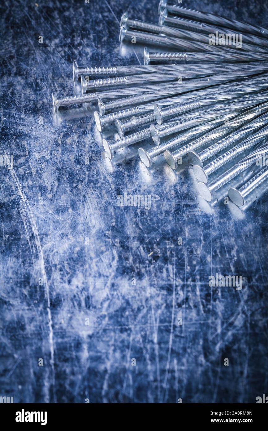 Composition de clous de construction en acier inoxydable sur le concept de construction de surface métallique rayée Banque D'Images