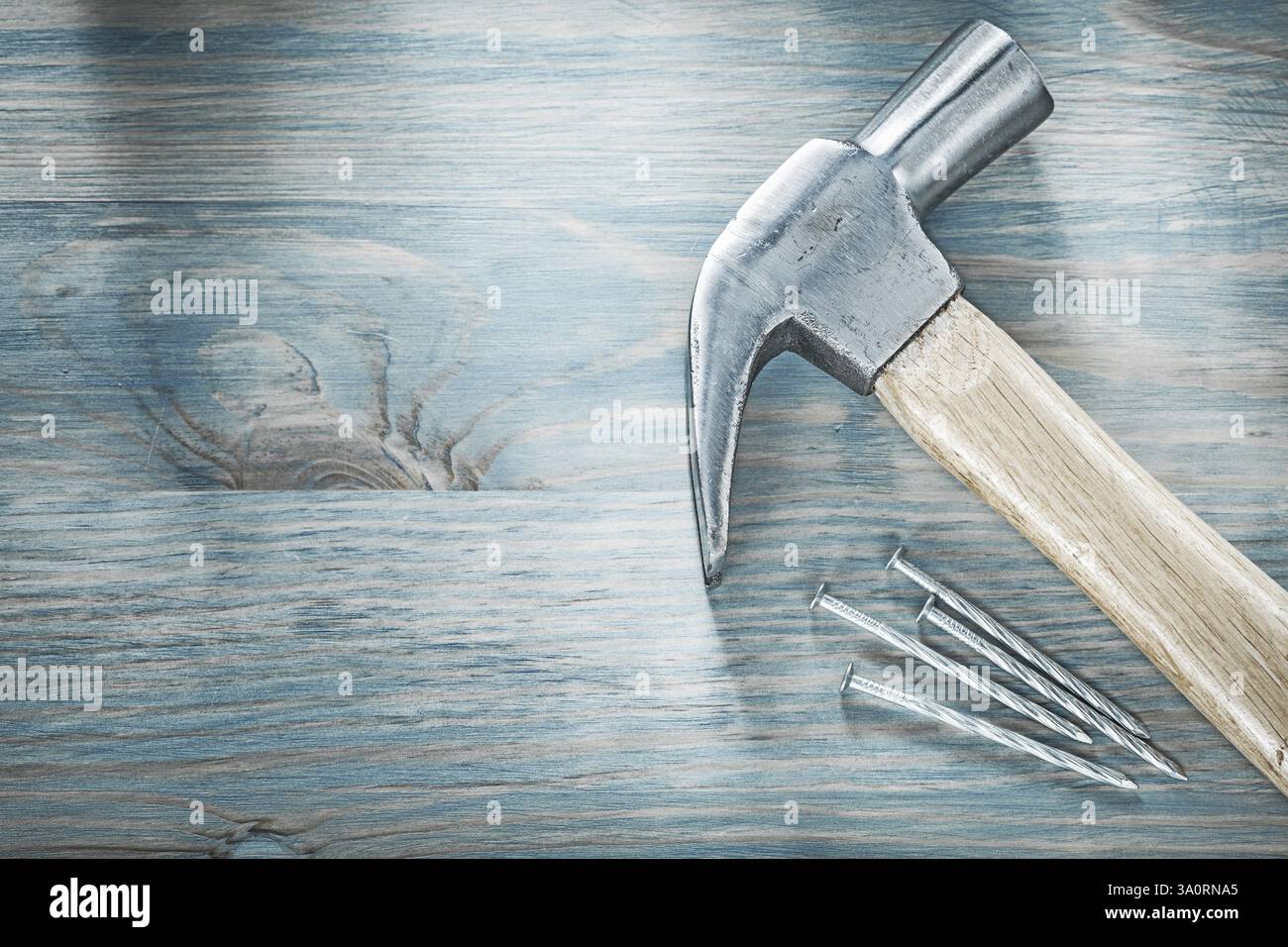 Clous métalliques de marteau de griffe sur le concept de construction de vue de dessus de planche en bois Banque D'Images