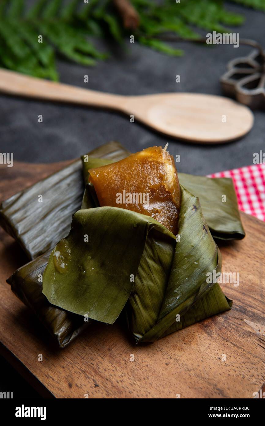 Lemet Cassava gâteau enveloppé dans une feuille de banane sur planche à découper en bois Banque D'Images