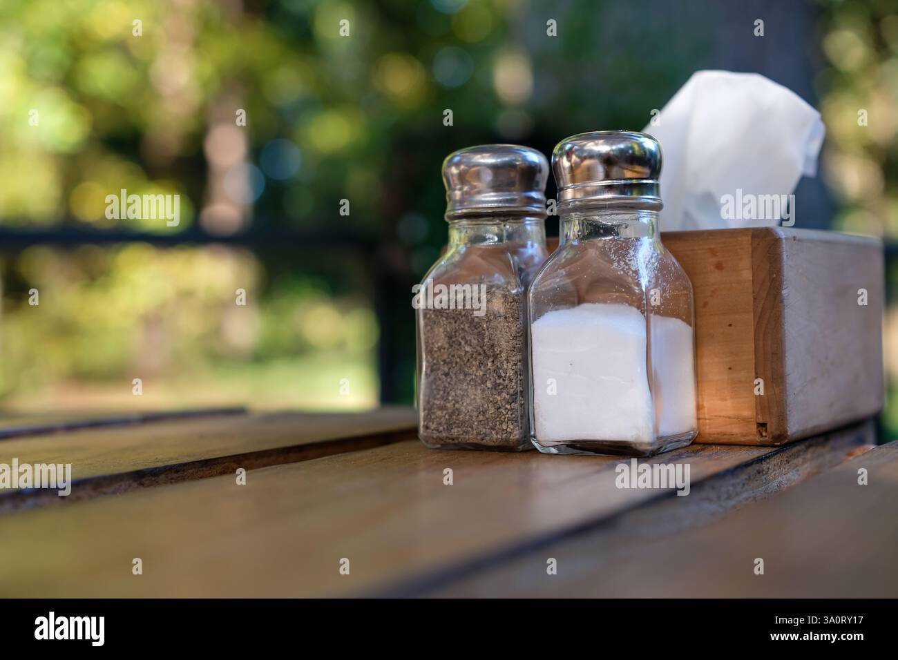 Table dans le restaurant de la forêt rustique. Les condiments et les serviettes sont sur la table en bois de palette. Scène sur la terrasse avant de manger. Banque D'Images