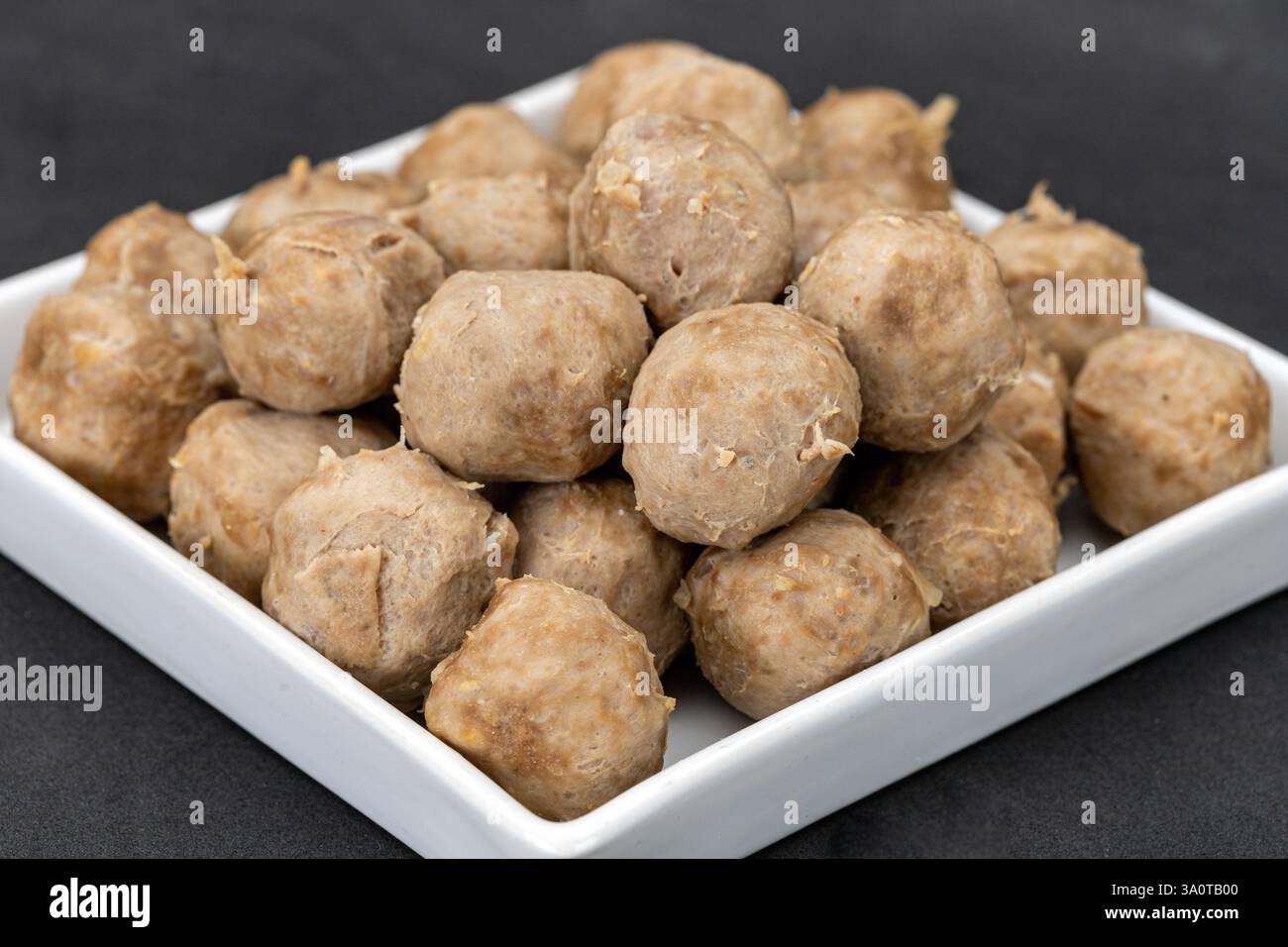 Les boulettes de viande de bœuf qui ont été bouillies et laissées de côté pendant une longue période ont rendu la peau extérieure peu appétissante dans un plat blanc. Banque D'Images