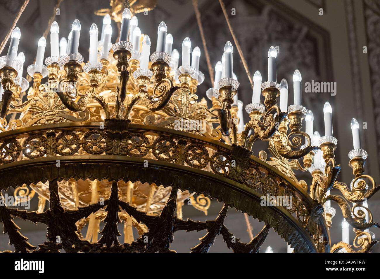 Lustre doré orné de motifs complexes et de multiples ampoules de fausses bougies, mettant l'accent sur le luxe et la sophistication. Idéal pour capturer grandiose Banque D'Images