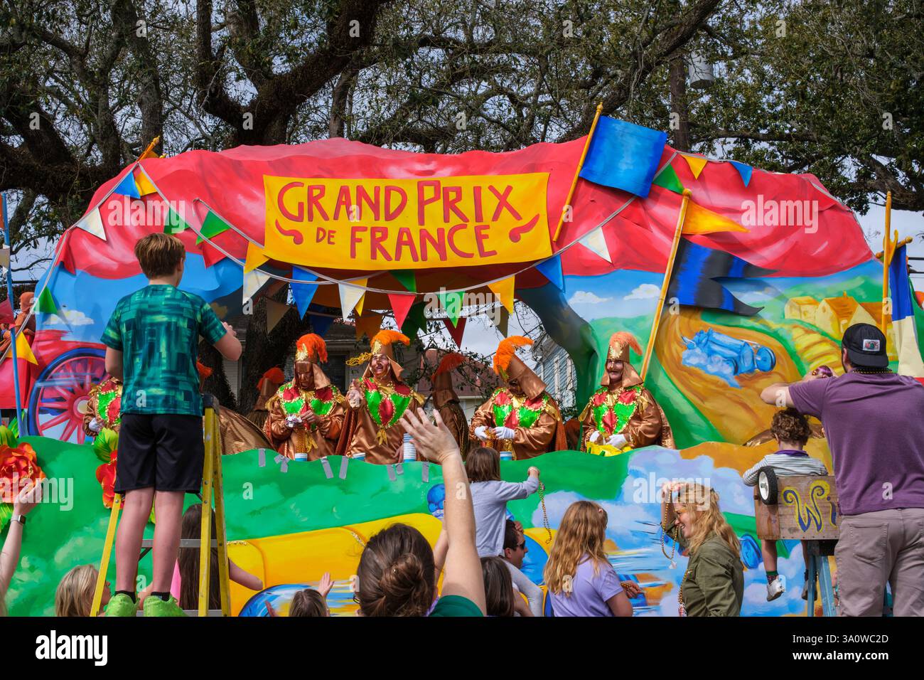 Nouvelle-Orléans, LOUISIANE, États-Unis - 4 mars 2025 : le Grand Prix de France flotte et les gens réclament des perles pendant la parade Rex le jour de mardi gras sur Napoleon Avenue dans le quartier Uptown Banque D'Images