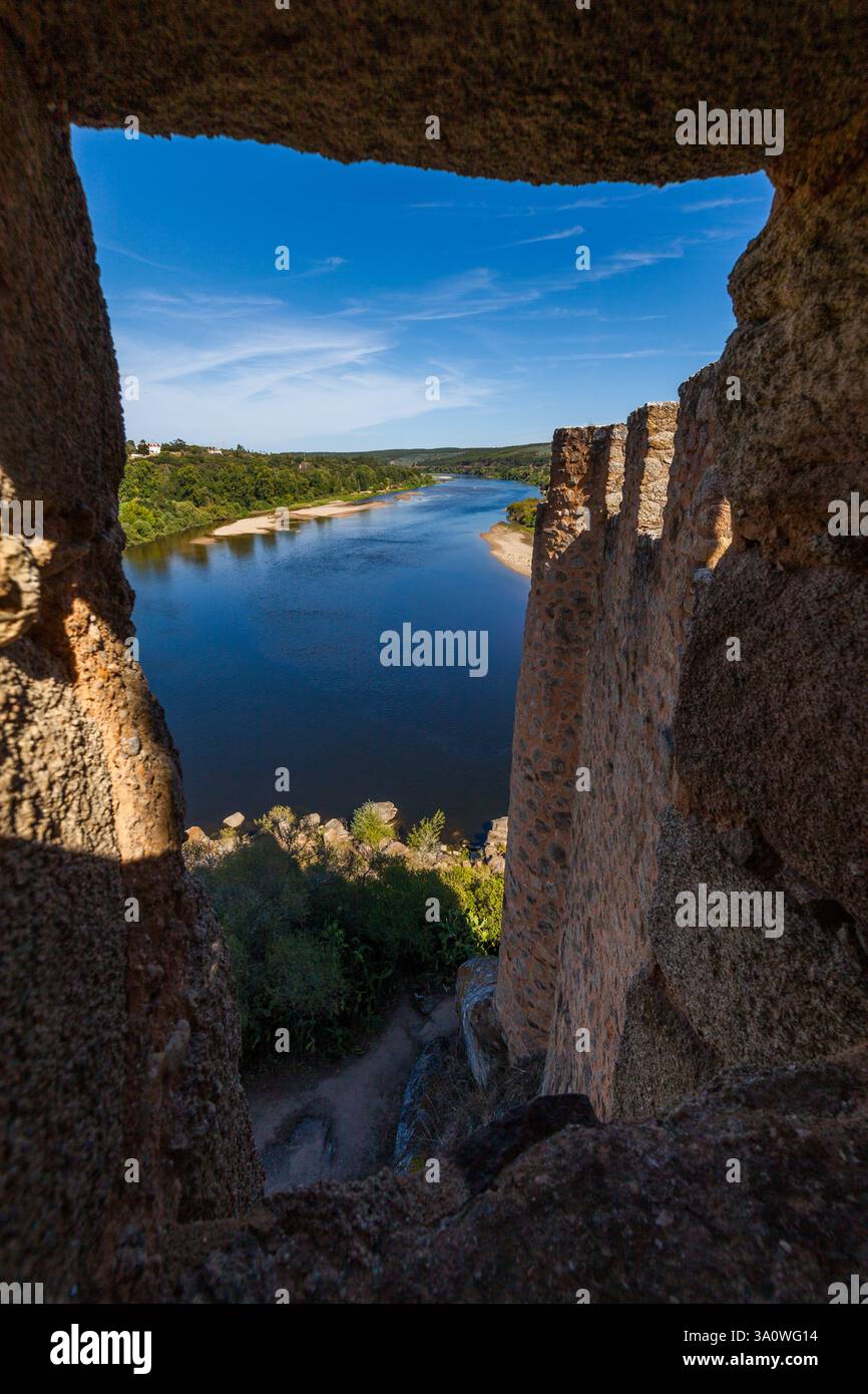 rivière tranquille encadrée par les murs de pierre brute d'une structure ancienne, probablement un château Banque D'Images