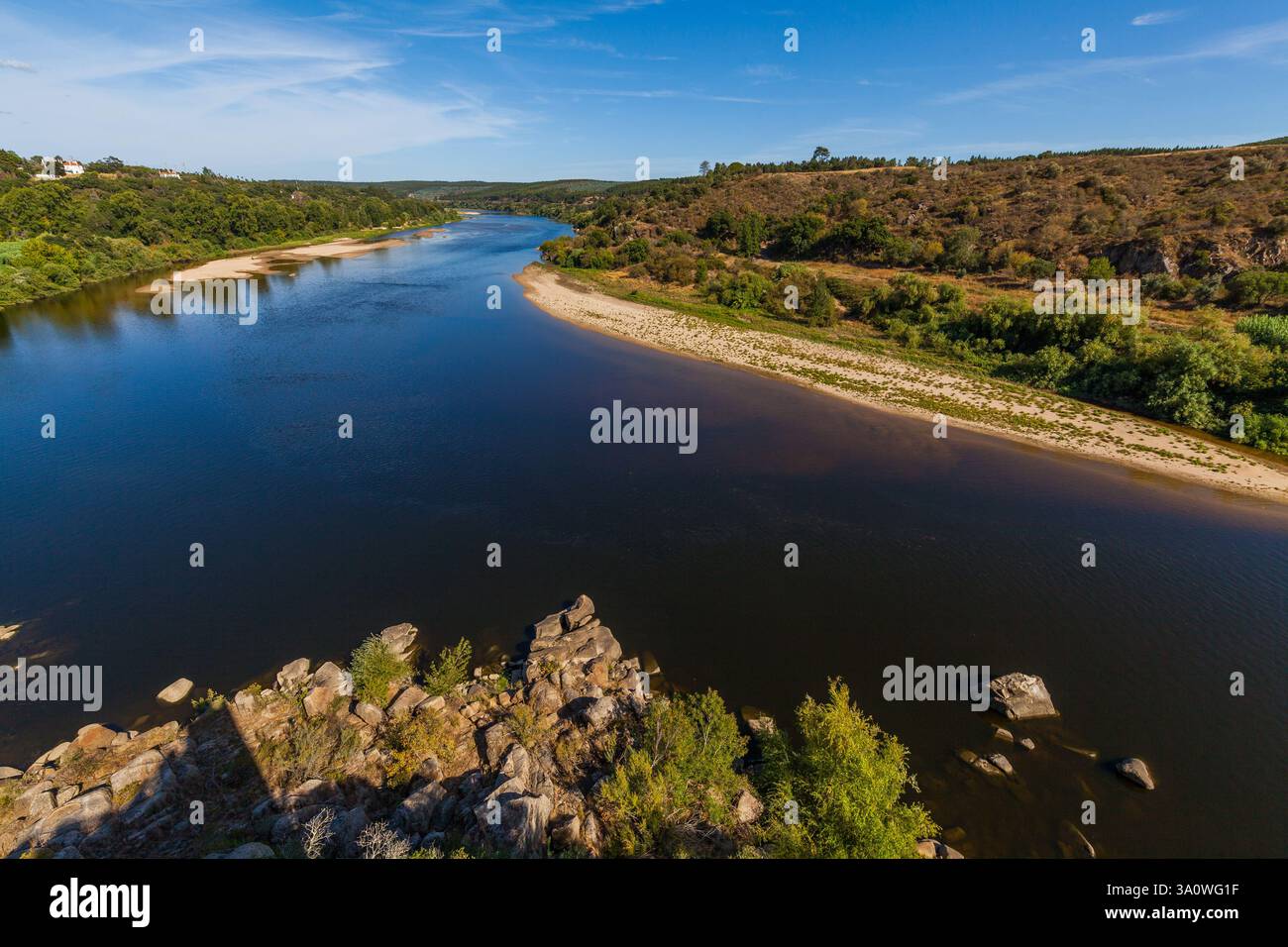 rivière tranquille encadrée par les murs de pierre brute d'une structure ancienne, probablement un château Banque D'Images
