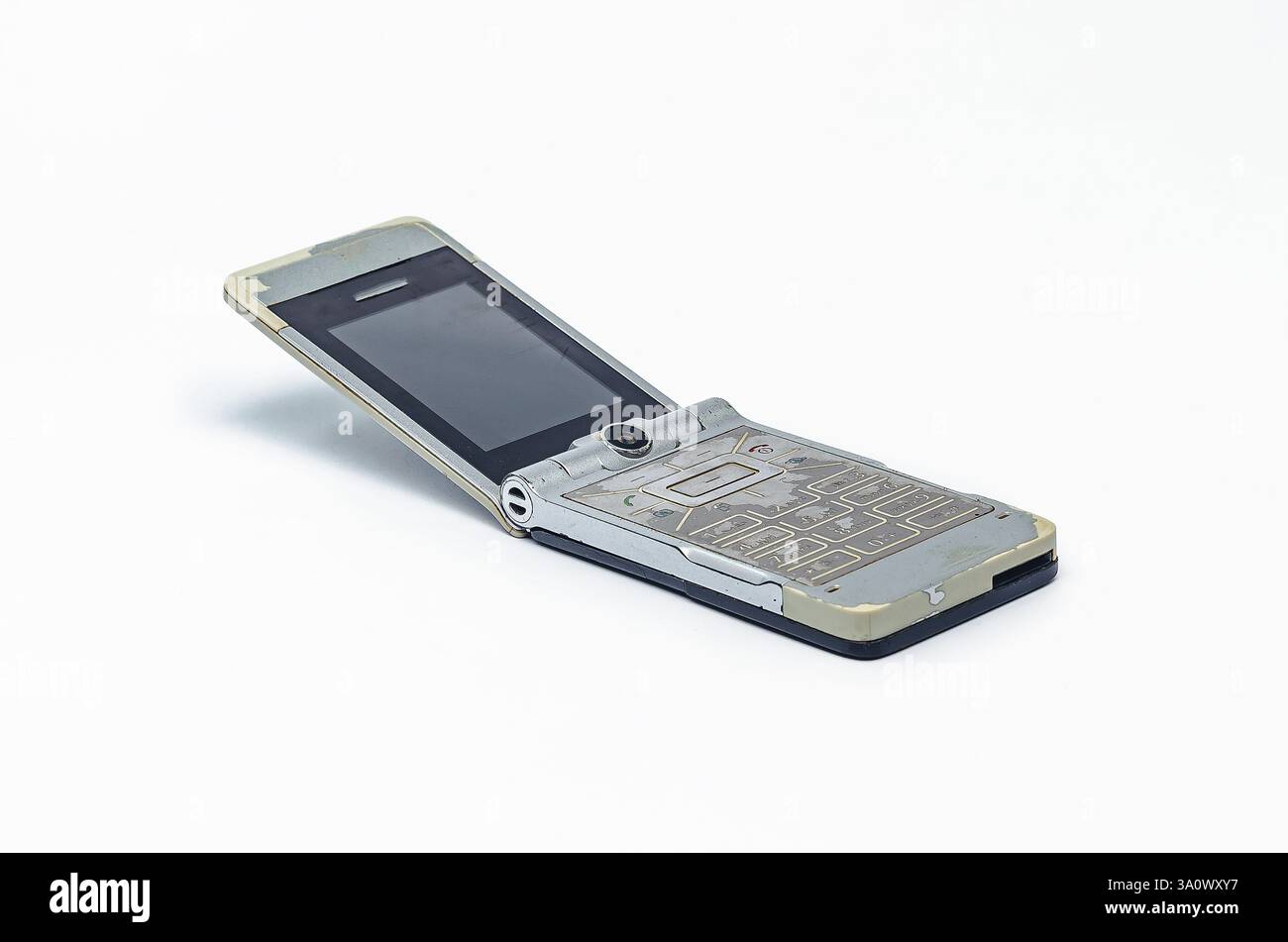 Téléphone rétro à rabat argenté avec écran rayé sur blanc Banque D'Images