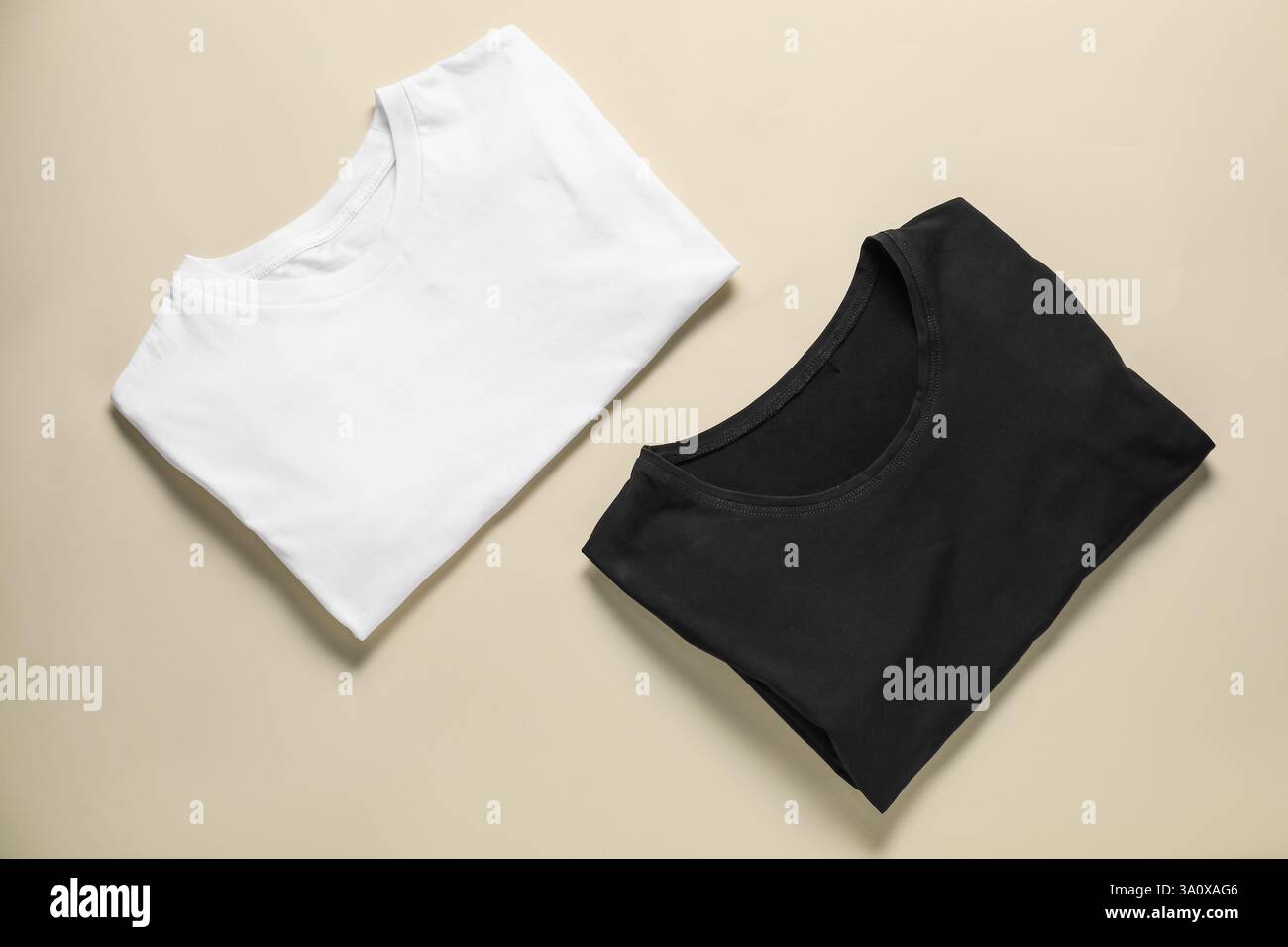 Deux t-shirts vierges sur fond beige, pose à plat. Maquette pour le design Banque D'Images Deux t-shirts vierges sur fond beige, pose à plat. Maquette pour le design Banque D'Images