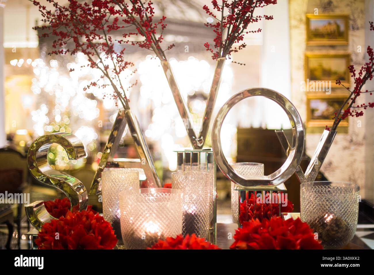 Décorations de Noël, Savoy Hotel, Londres. De grandes lettres en miroir désignent « SAVOY ». Baies rouges et fleurs. Banque D'Images