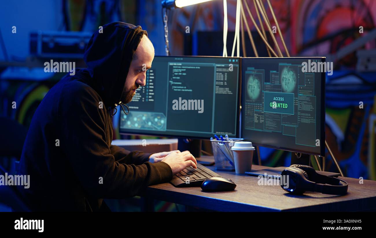 Hacker dans la base cachée excité après avoir réussi à dépasser les mesures anti-sabotage mises en œuvre par les entreprises pour protéger leurs produits. Joyeux cracker célébrant après avoir réussi à pirater des logiciels Banque D'Images