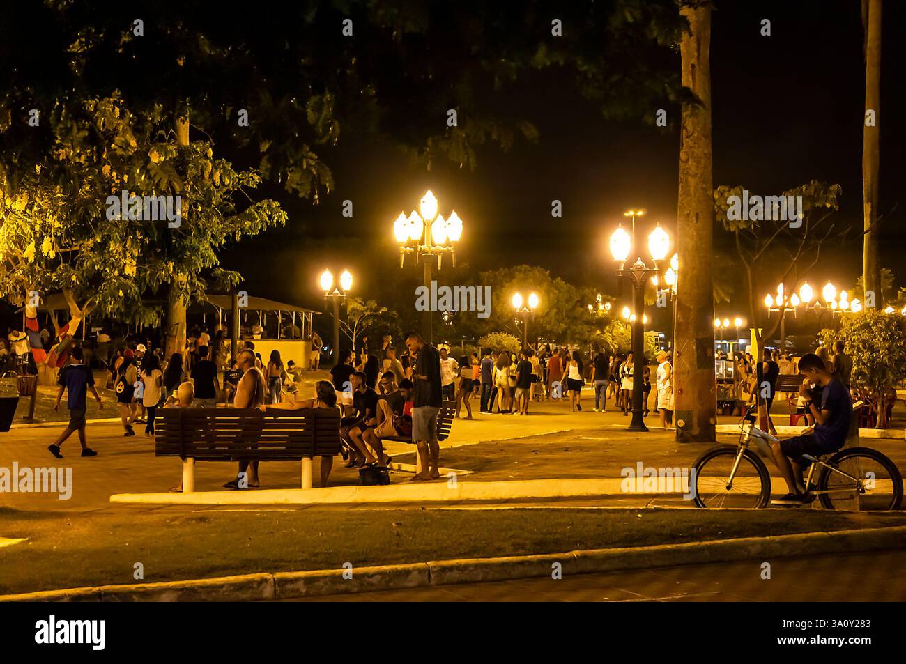 Vue panoramique sur la zone piétonne animée de la place Menino João Helio remplie de visiteurs profitant d'une promenade nocturne animée sous les lumières de la rue en été Banque D'Images