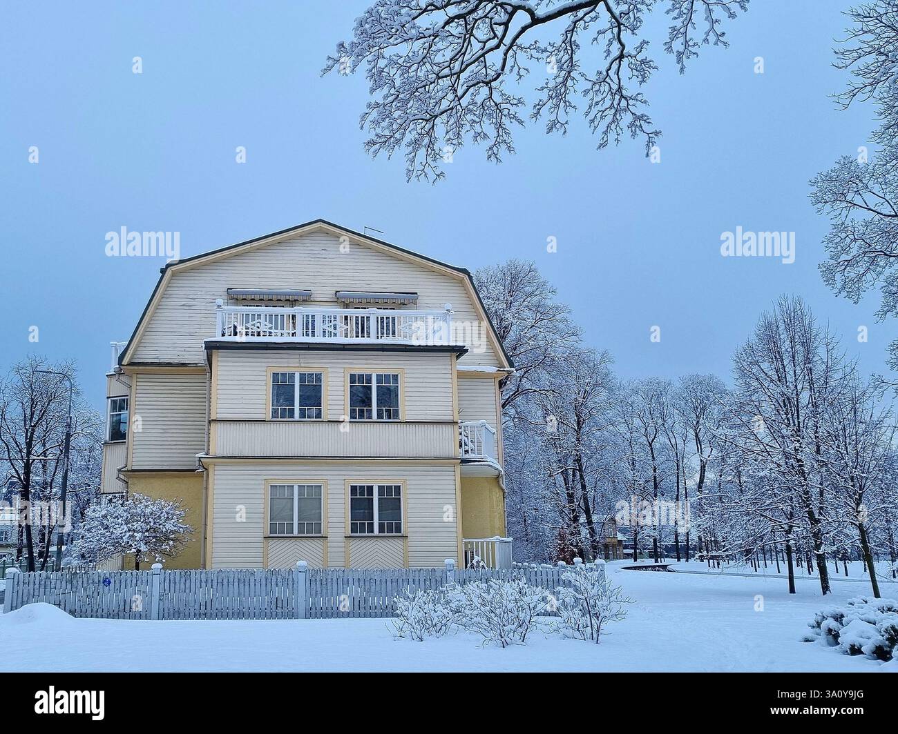 Trains de banlieue orange modernes sur une plate-forme enneigée de la gare de Tallinn attendant les passagers Banque D'Images