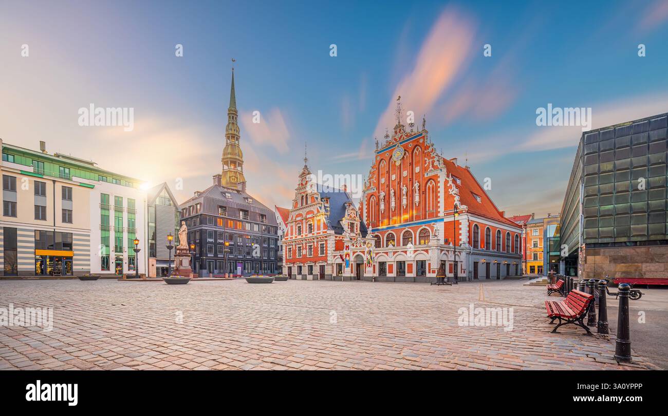 Place de l’Hôtel de ville avec Maison des Blackheads et église Saint-Pierre dans la vieille ville de Riga, capitale de la Lettonie au coucher du soleil Banque D'Images