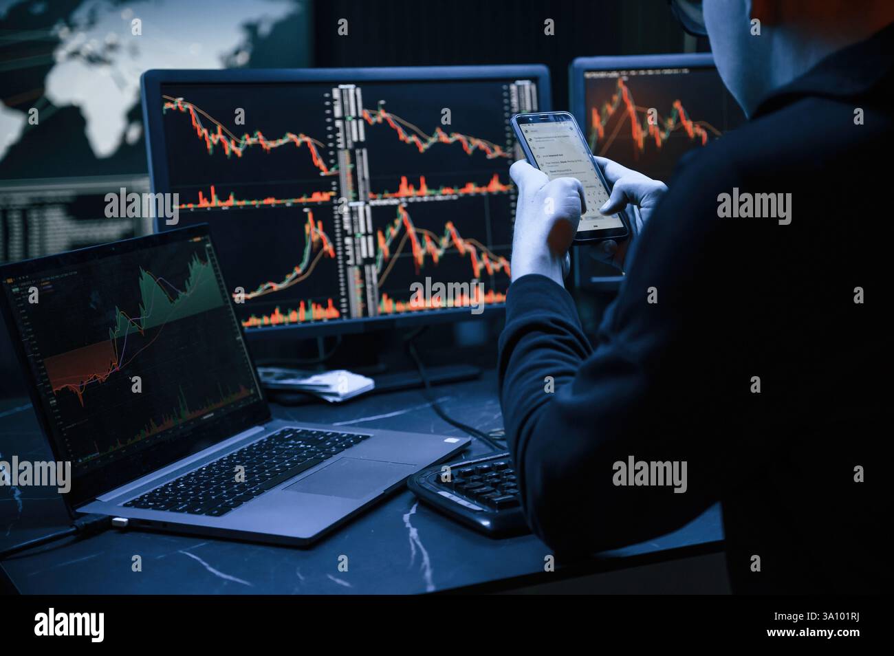 Analyste financier travaillant sur un ordinateur avec poste de travail multi-moniteurs avec des graphiques en temps réel des actions, des matières premières et des marchés des changes Banque D'Images