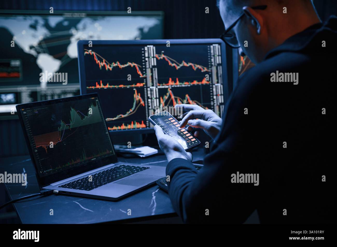 Analyste financier travaillant sur un ordinateur avec poste de travail multi-moniteurs avec des graphiques en temps réel des actions, des matières premières et des marchés des changes Banque D'Images