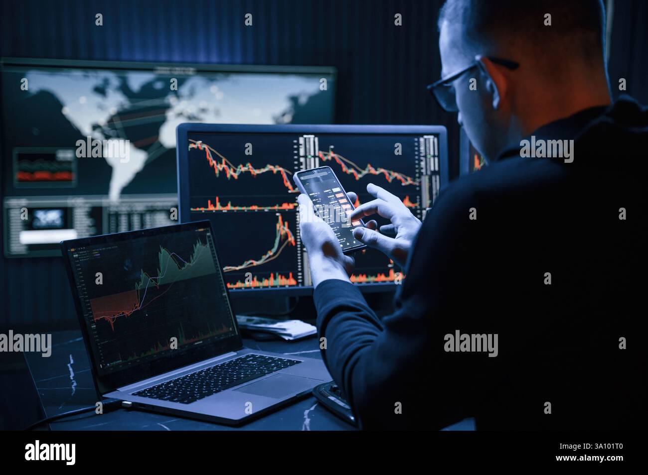 Analyste financier travaillant sur un ordinateur avec poste de travail multi-moniteurs avec des graphiques en temps réel des actions, des matières premières et des marchés des changes Banque D'Images
