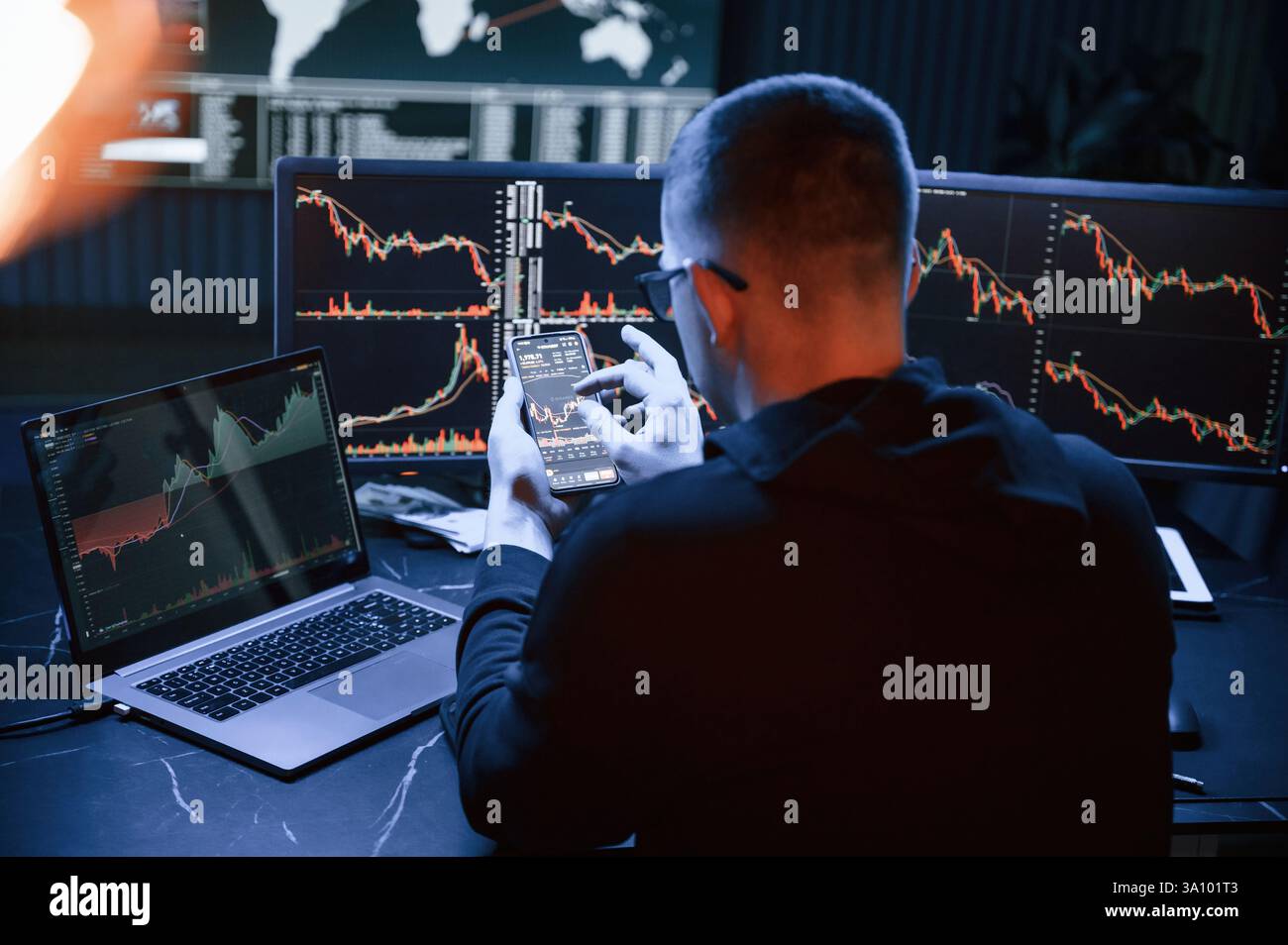 Analyste financier travaillant sur un ordinateur avec poste de travail multi-moniteurs avec des graphiques en temps réel des actions, des matières premières et des marchés des changes Banque D'Images