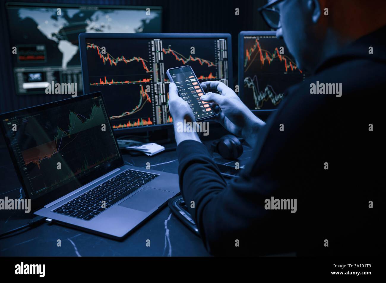 Analyste financier travaillant sur un ordinateur avec poste de travail multi-moniteurs avec des graphiques en temps réel des actions, des matières premières et des marchés des changes Banque D'Images