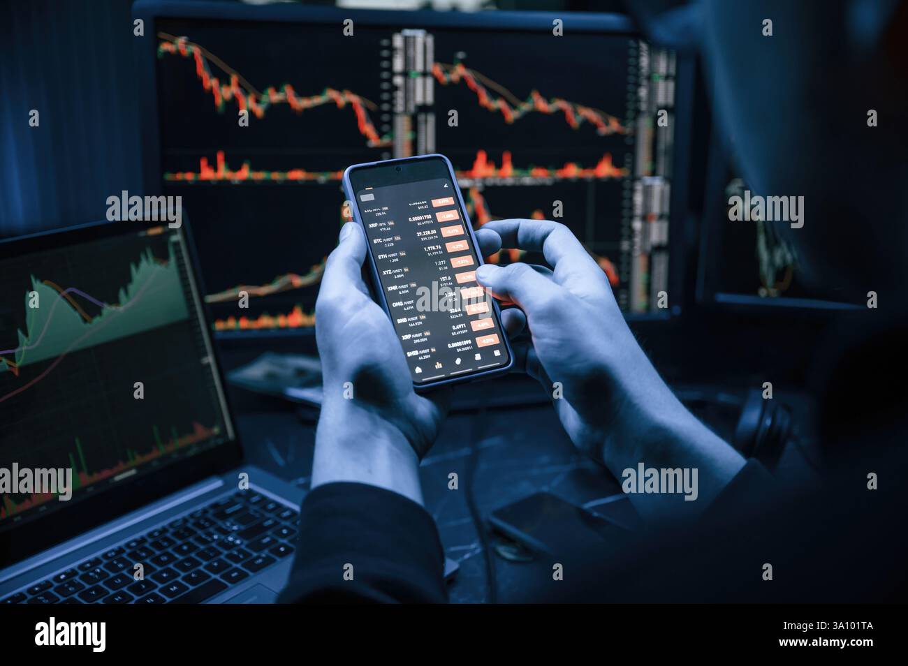 Analyste financier travaillant sur un ordinateur avec poste de travail multi-moniteurs avec des graphiques en temps réel des actions, des matières premières et des marchés des changes Banque D'Images