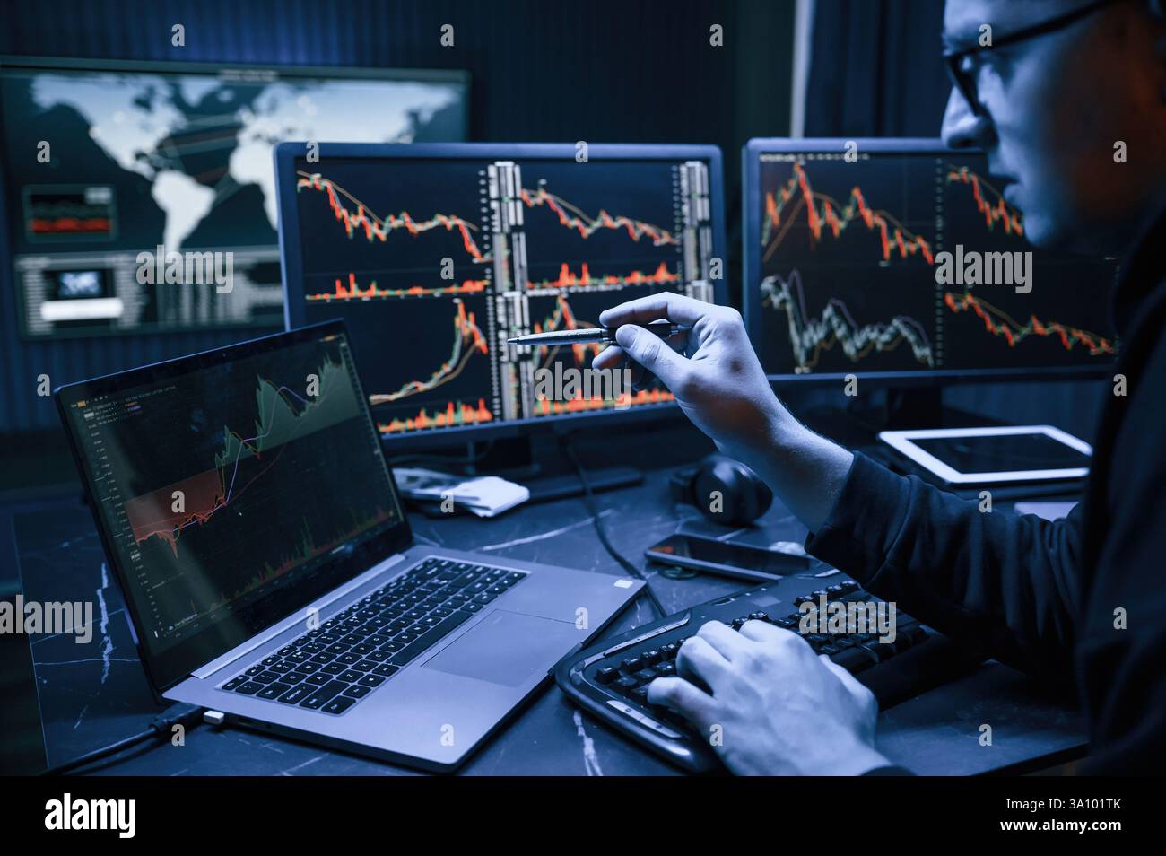 Analyste financier travaillant sur un ordinateur avec poste de travail multi-moniteurs avec des graphiques en temps réel des actions, des matières premières et des marchés des changes Banque D'Images
