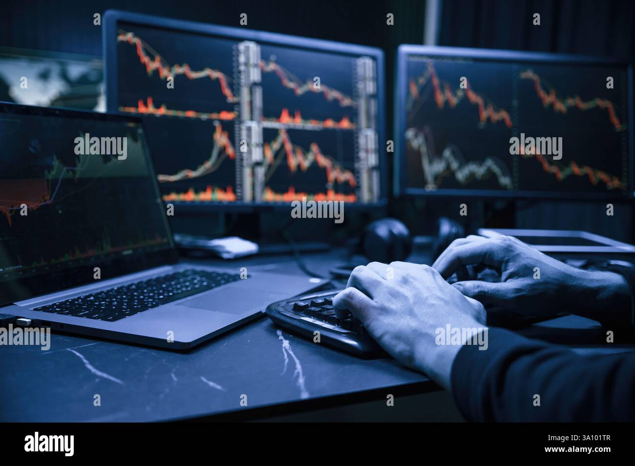 Analyste financier travaillant sur un ordinateur avec poste de travail multi-moniteurs avec des graphiques en temps réel des actions, des matières premières et des marchés des changes Banque D'Images