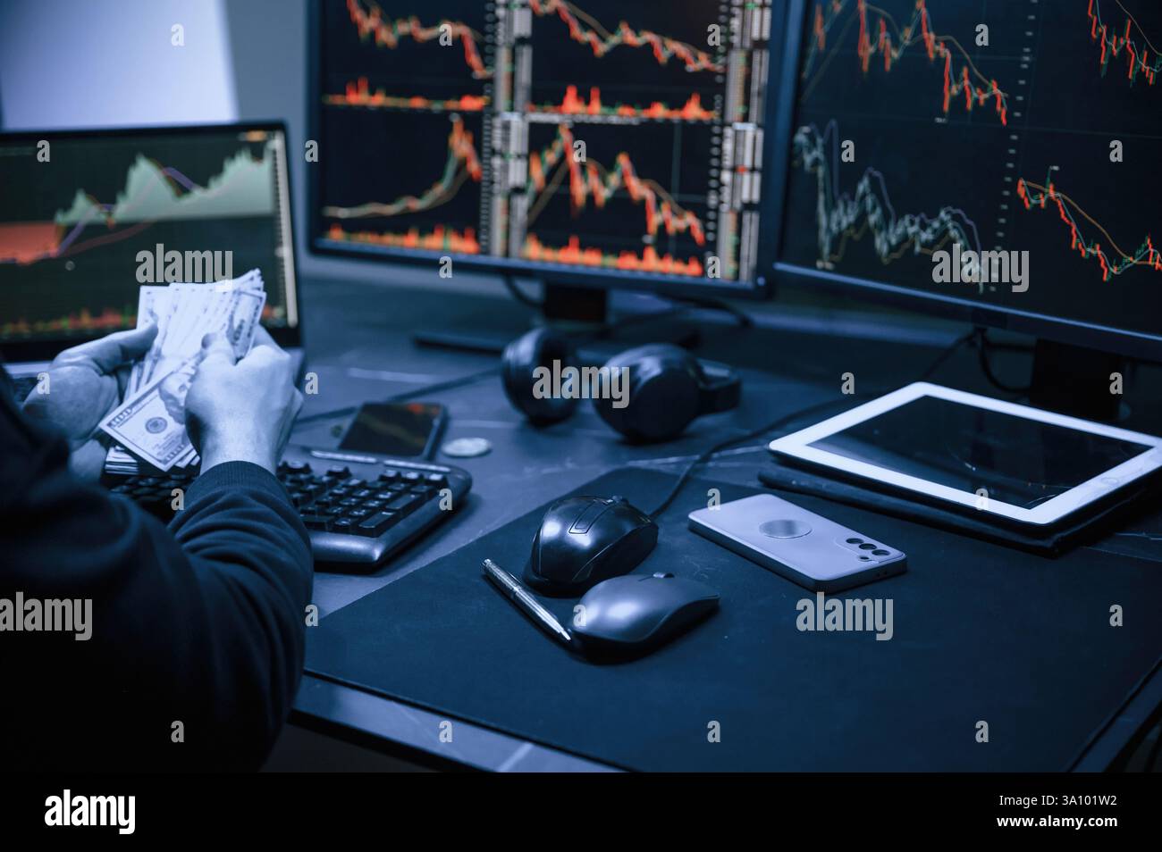 Analyste financier travaillant sur un ordinateur avec poste de travail multi-moniteurs avec des graphiques en temps réel des actions, des matières premières et des marchés des changes Banque D'Images