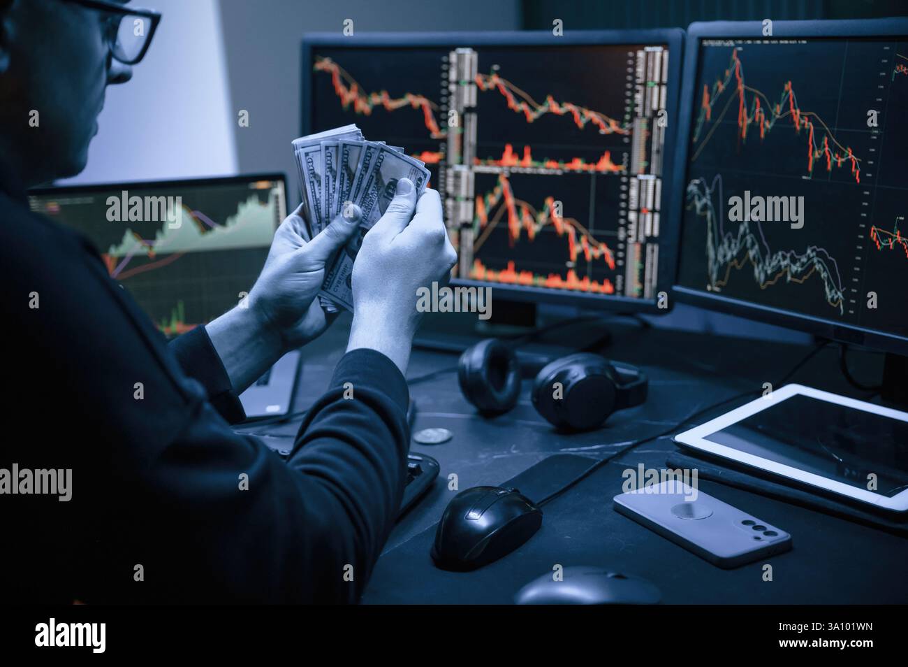 Analyste financier travaillant sur un ordinateur avec poste de travail multi-moniteurs avec des graphiques en temps réel des actions, des matières premières et des marchés des changes Banque D'Images