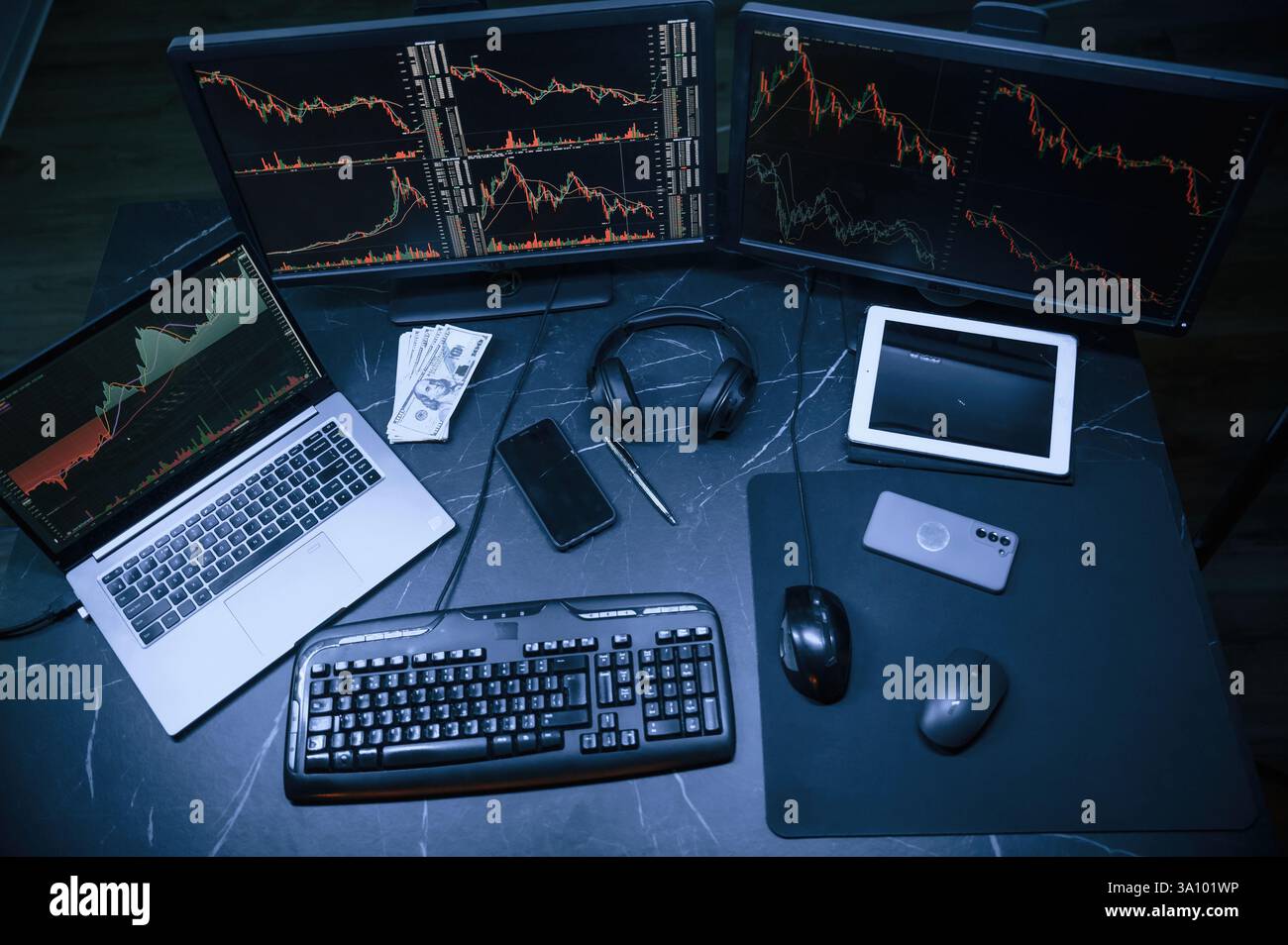 Analyste financier travaillant sur un ordinateur avec poste de travail multi-moniteurs avec des graphiques en temps réel des actions, des matières premières et des marchés des changes Banque D'Images