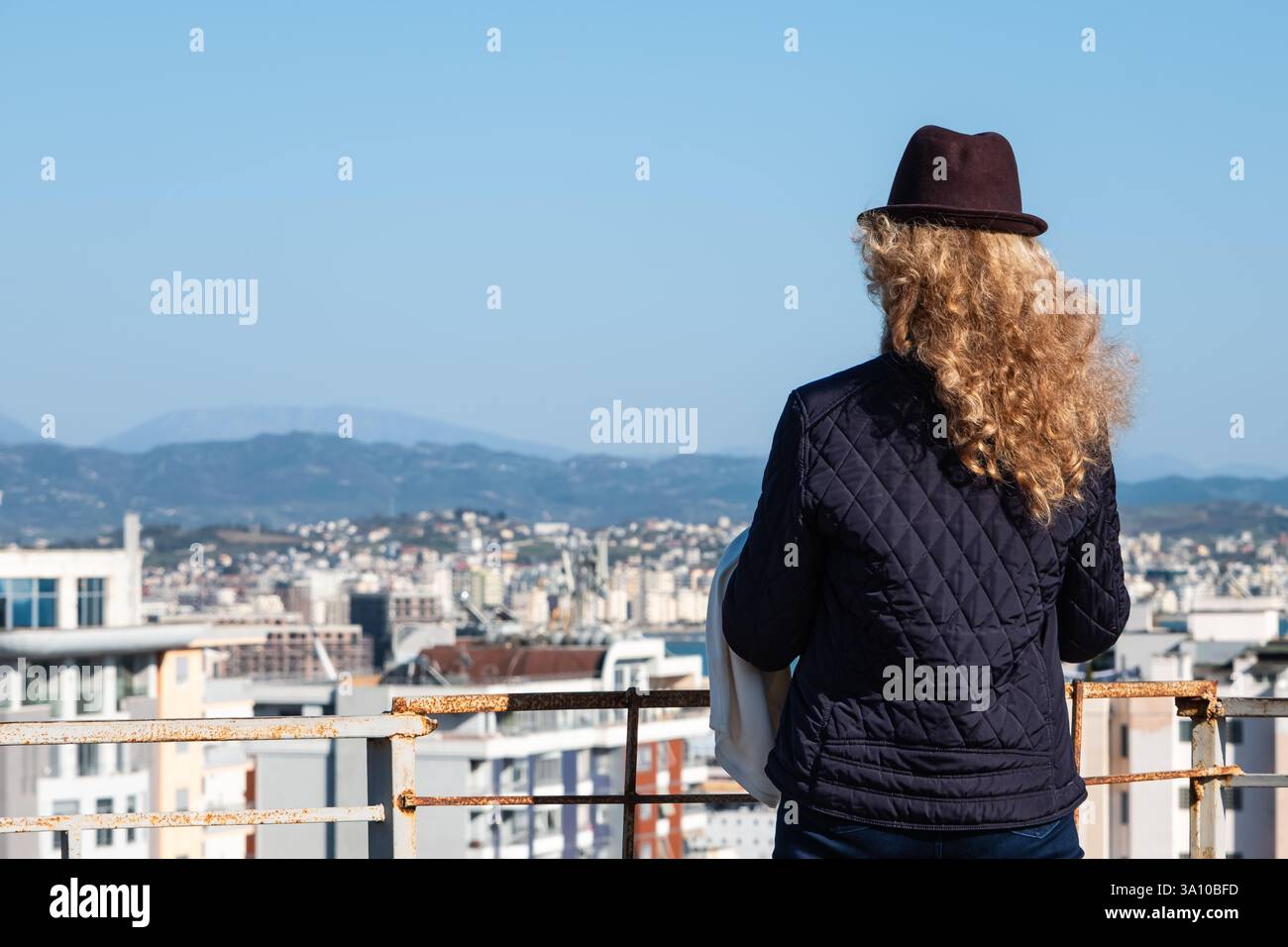 Voyageuse femme regardant dans la distance contre le panorama de la ville de Durres Albanie. Femme élégante profitant de la vue sur une ville depuis la terrasse d'observation Banque D'Images