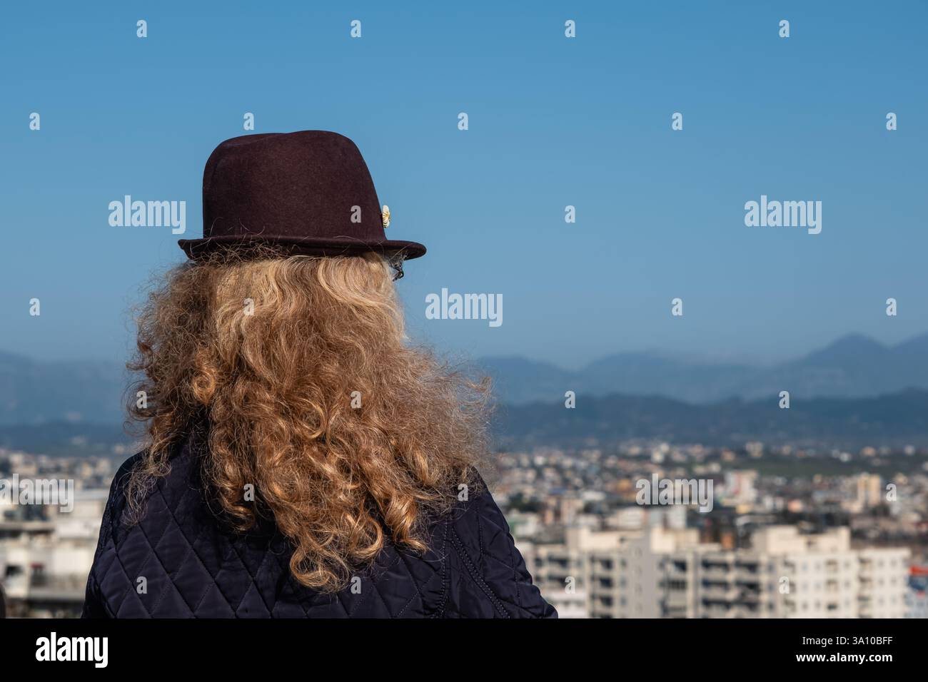 Voyageuse femme regardant dans la distance contre le panorama de la ville de Durres Albanie. Femme élégante profitant de la vue sur une ville depuis la terrasse d'observation Banque D'Images
