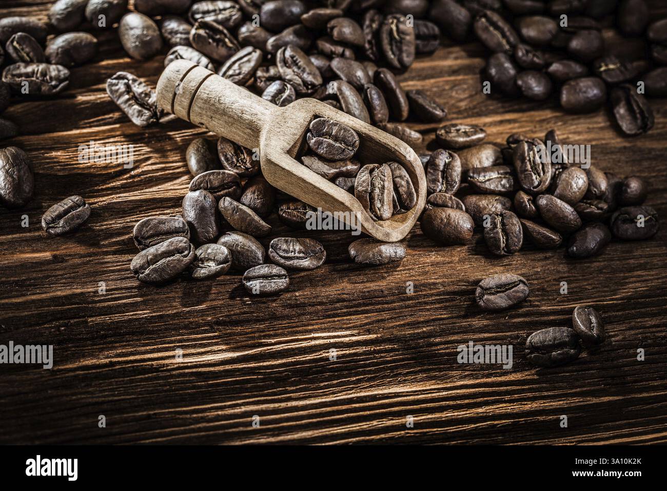 Grains de café en scoop sur planche de bois vintage Banque D'Images